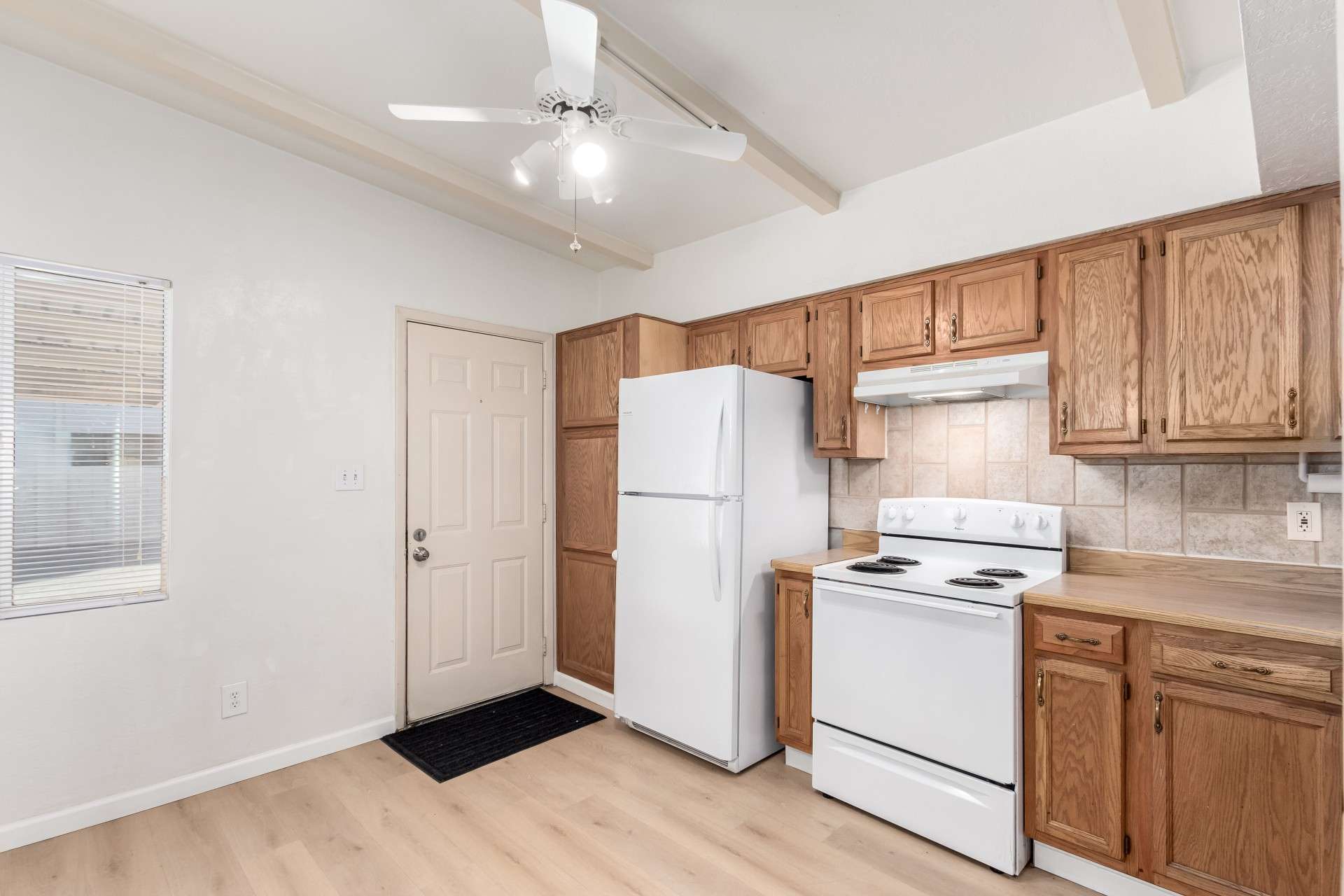 9 of 26. A timeless kitchen design featuring wood cabinetry, a tiled backsplash, and a spacious layout. Whether you're a home chef or enjoy casual cooking, this kitchen provides the perfect blend of charm and functionality in a prime Phoenix location.