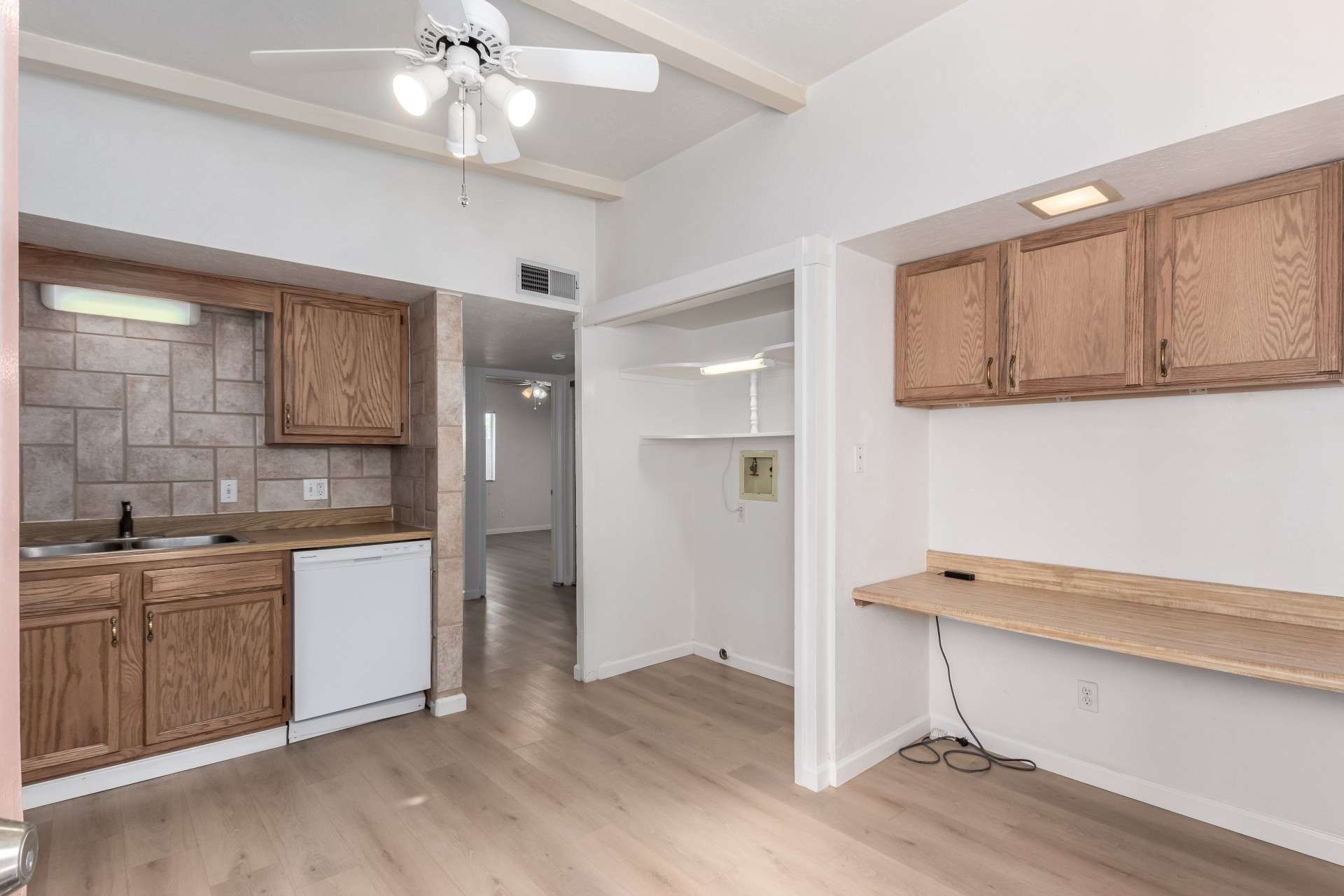 13 of 26. This versatile kitchen layout includes a dedicated workspace, perfect for meal planning or a home office setup. Featuring wood cabinetry, a tiled backsplash, and built-in shelving, this kitchen combines efficiency and style in a desirable Phoenix neighborhood.