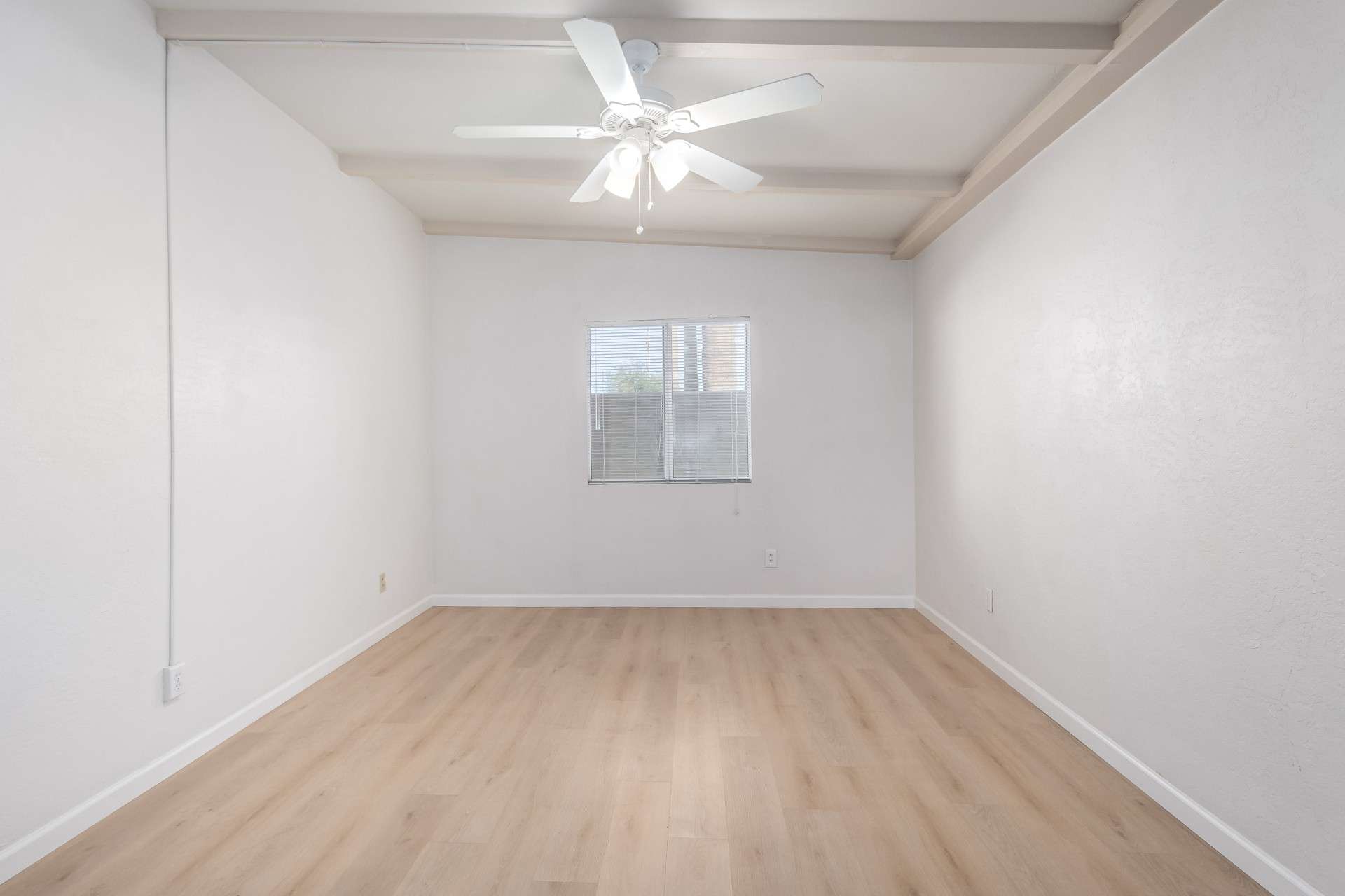 16 of 26. Featuring vaulted ceilings, a ceiling fan, and modern laminate flooring, this open and spacious bedroom is perfect for relaxation. The fresh updates add to the contemporary charm of this Phoenix home.