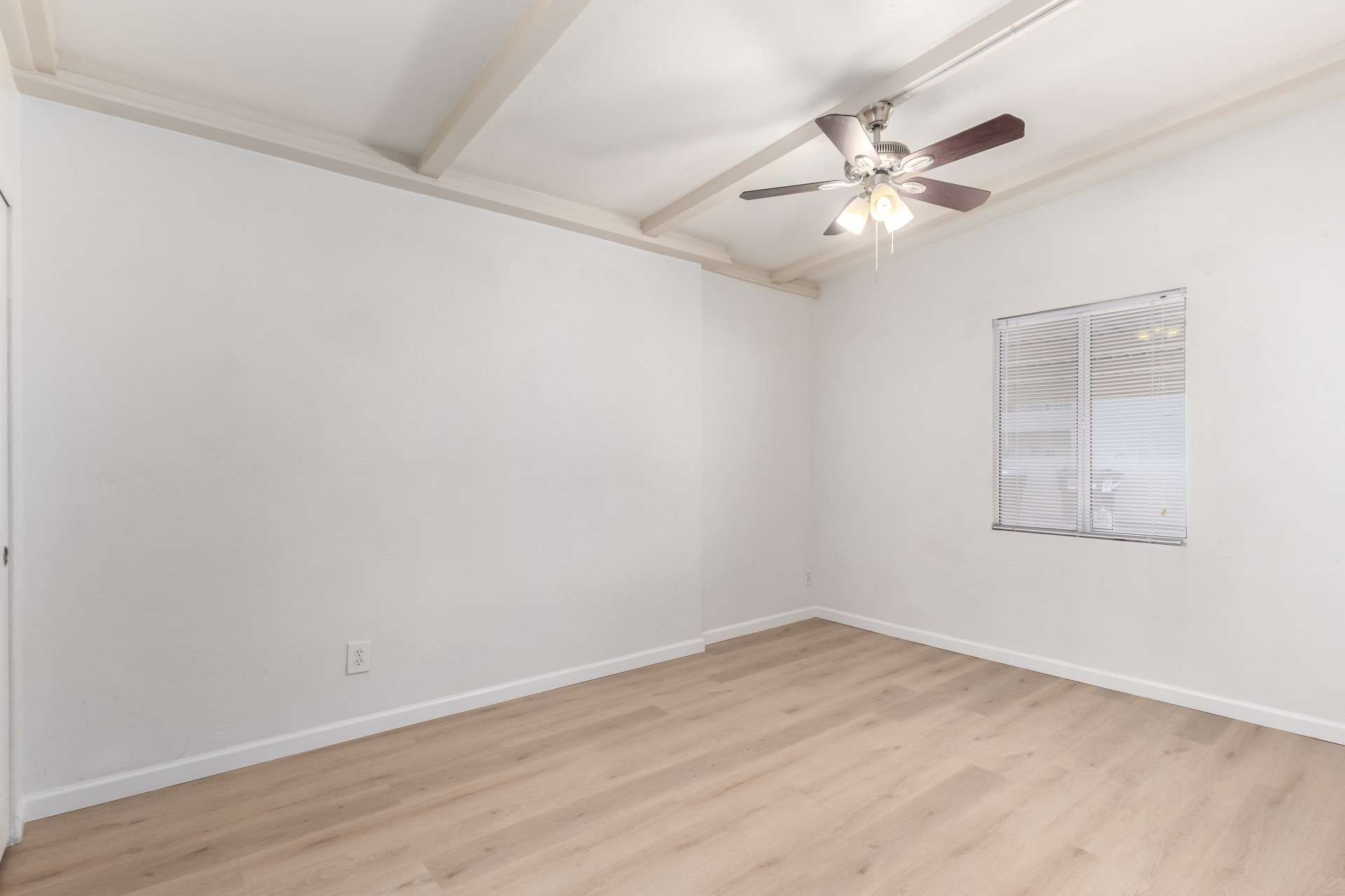 17 of 26. This secondary bedroom offers modern flooring, a ceiling fan, and a large window to maximize natural light. Whether used as a guest room, home office, or creative space, this room is full of potential in a well-located Phoenix condo.