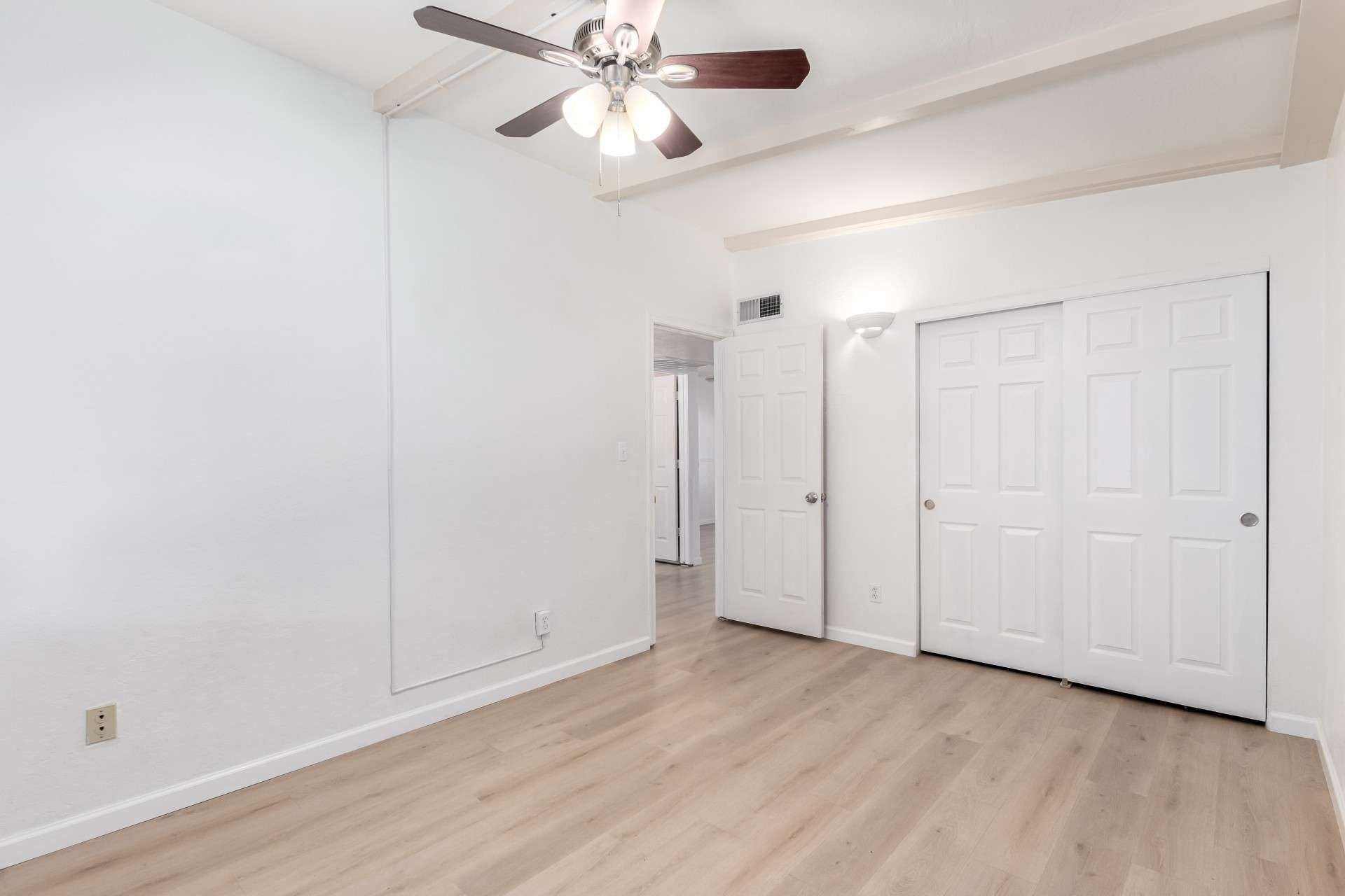 18 of 26. A well-sized bedroom with an open layout, this space includes closet storage, a ceiling fan, and modern flooring. Perfect for guests or an office, this room adds flexibility to this charming Phoenix property.