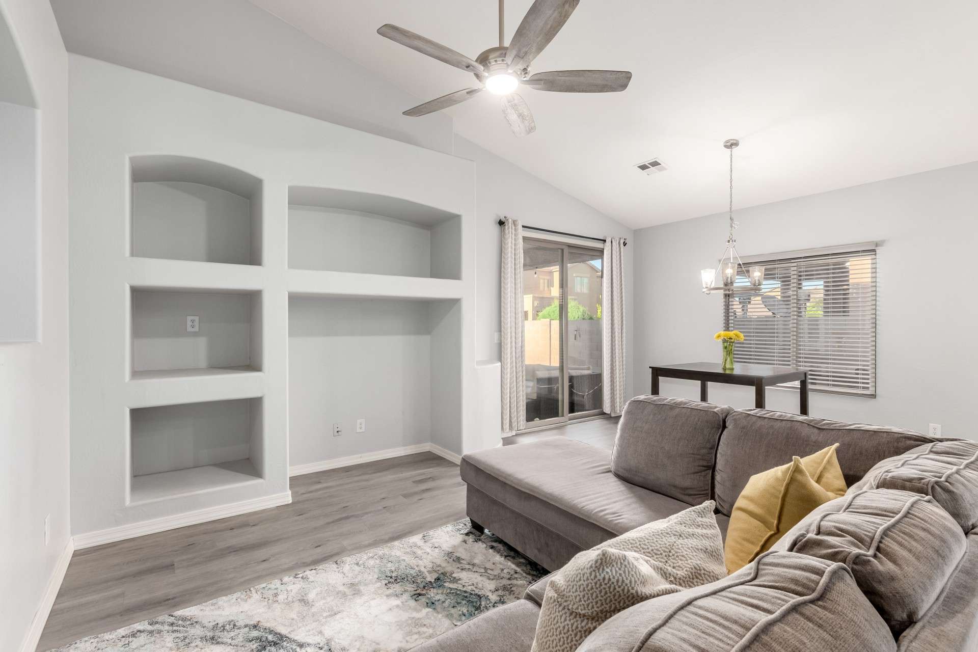 10 of 37. A modern great room layout blends functionality and style with custom built-in shelving, a ceiling fan, and direct access to the backyard. Natural light and tall ceilings enhance the open feel of this central gathering space.