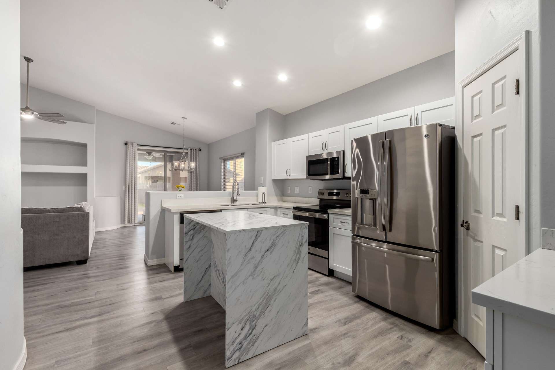 13 of 37. A standout feature of the home, this kitchen offers a marble-look island, stainless steel appliances, and bright white cabinetry. It blends modern design with everyday functionality in a space made to impress.