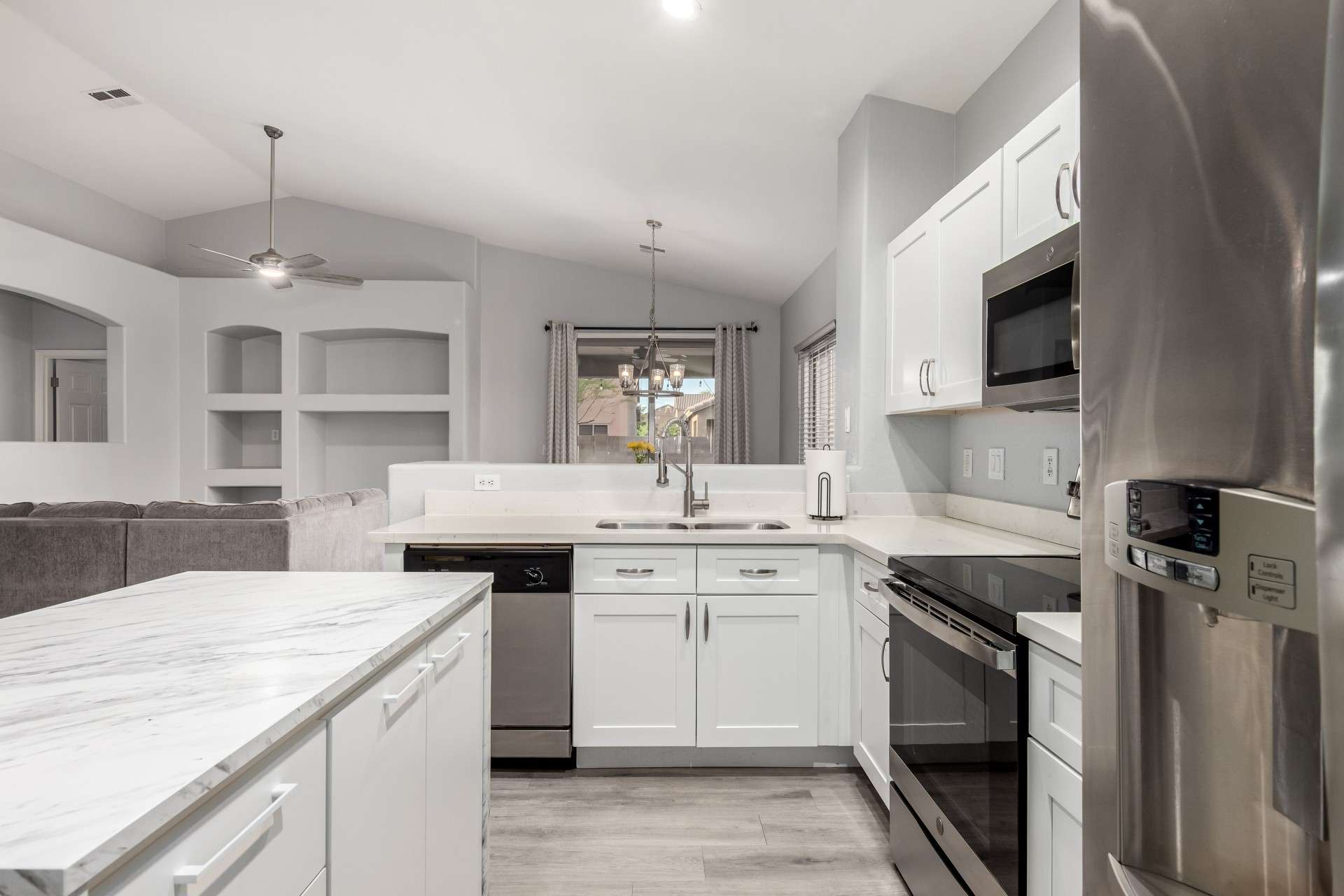 14 of 37. This open kitchen offers a seamless connection to the living area, with a central island ideal for cooking prep or casual seating. The layout emphasizes light, space, and contemporary style throughout.