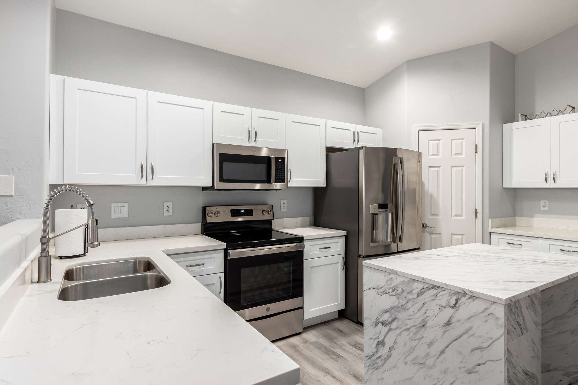 15 of 37. Function meets form in this corner of the kitchen, where you'll find clean white quartz surfaces, a deep stainless sink, and an upgraded faucet. The light, bright finishes offer a timeless aesthetic.
