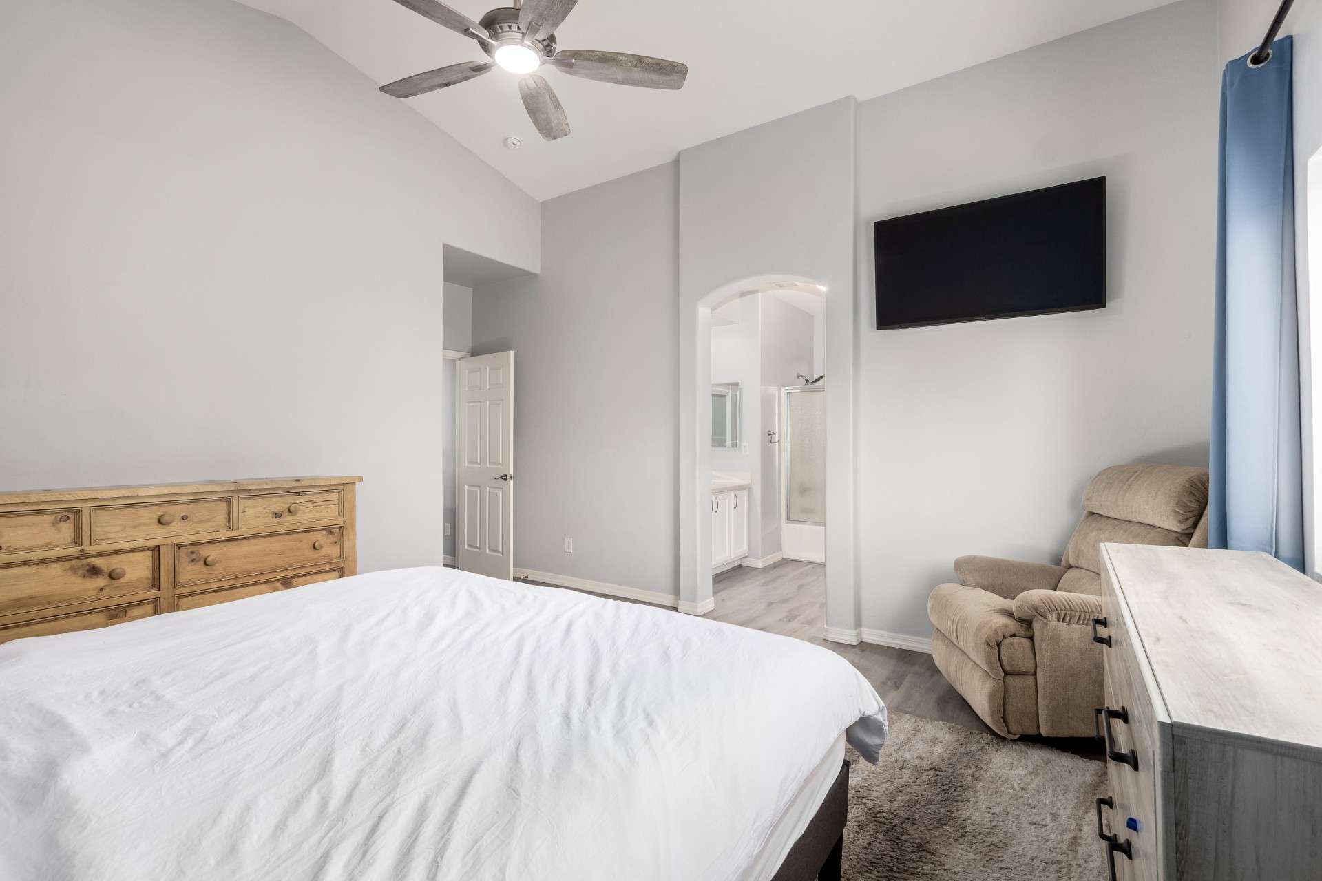 17 of 37. Step into the owner s suite, where a graceful arched doorway leads to the ensuite bath. Vaulted ceilings and upgraded flooring create a warm, elevated space ideal for rest and privacy.