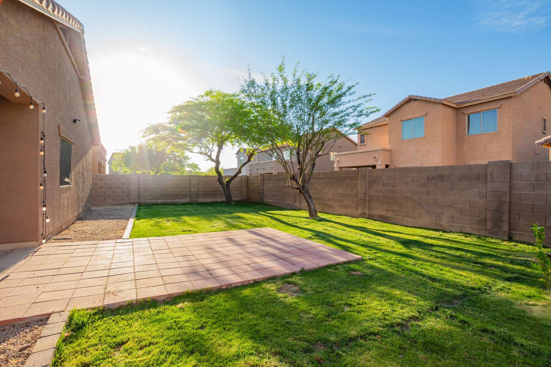 35 of 37. The beautifully maintained backyard offers a generous grassy area, mature shade trees, and a paved patio pad ideal for grilling, dining, or hosting under open skies. A perfect outdoor escape in a quiet residential setting.
