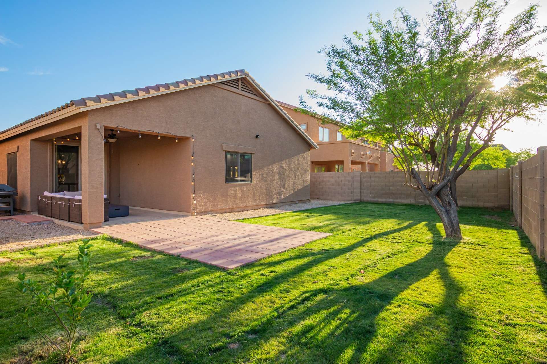 2 of 37. This expansive backyard view showcases a large covered patio, paver flooring extension, and lush lawn ideal for outdoor dining, weekend lounging, or future landscaping projects. A perfect blend of functionality and charm.
