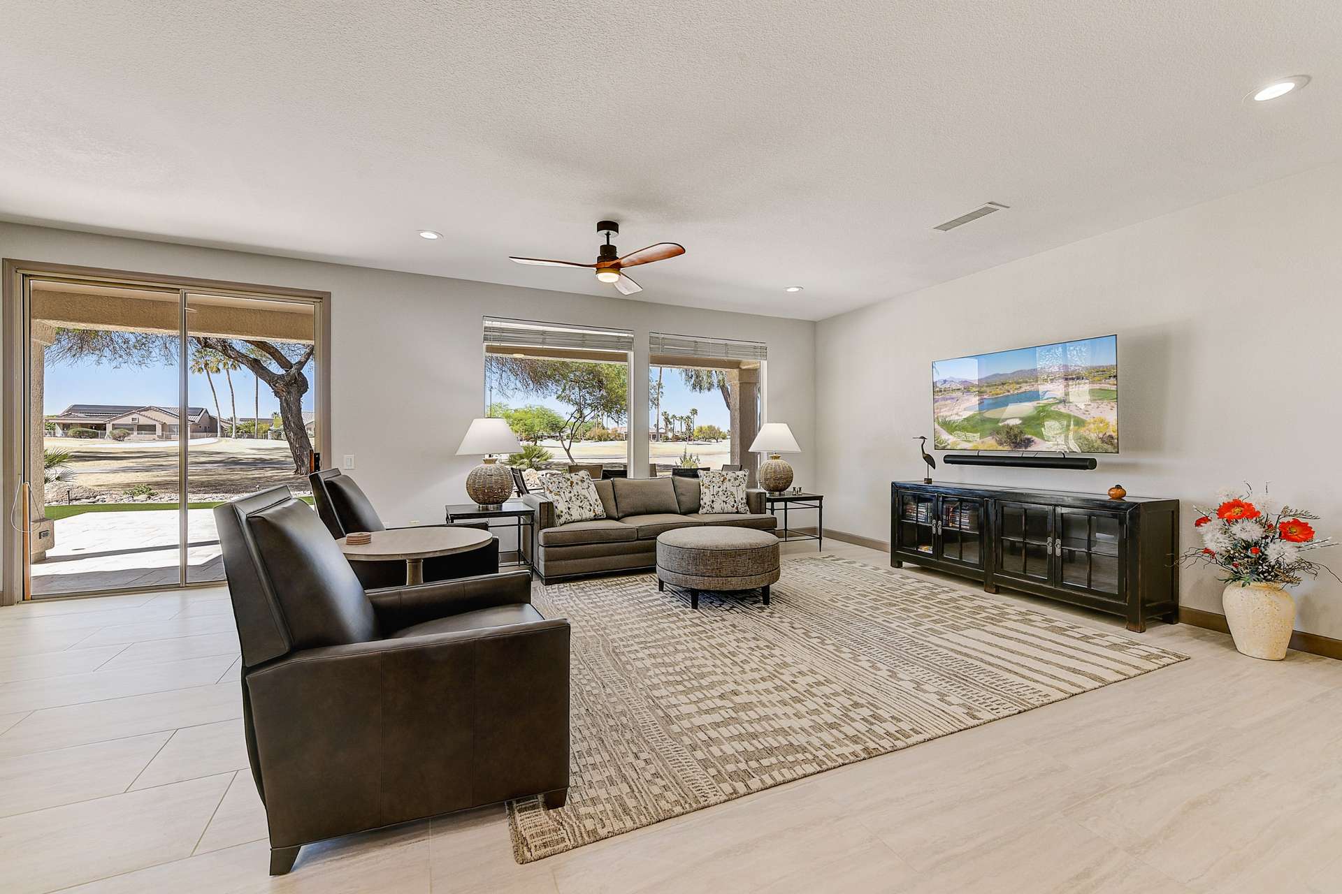 2 of 35. This expansive great room is designed for comfort and relaxation, with stunning views of the Desert Springs Golf Course just beyond your windows. Natural light, soft hues, and wide-open space invite peaceful living and stylish gatherings.