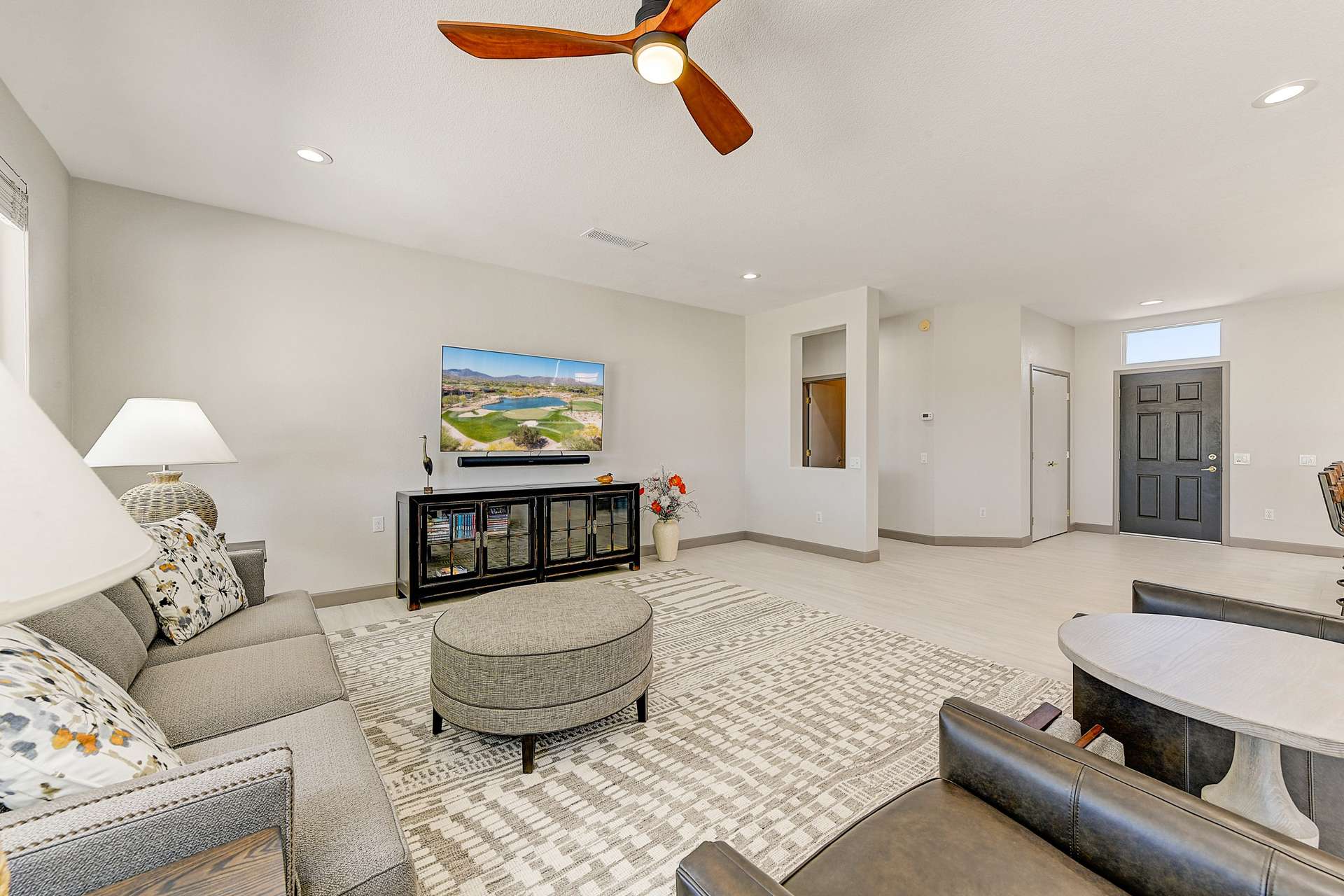 3 of 35. A serene retreat for everyday living, this room is highlighted by custom ceiling fan lighting, a neutral color palette, and large-format tile flooring. Watch the Arizona landscape unfold right from your sofa in this thoughtfully updated interior.