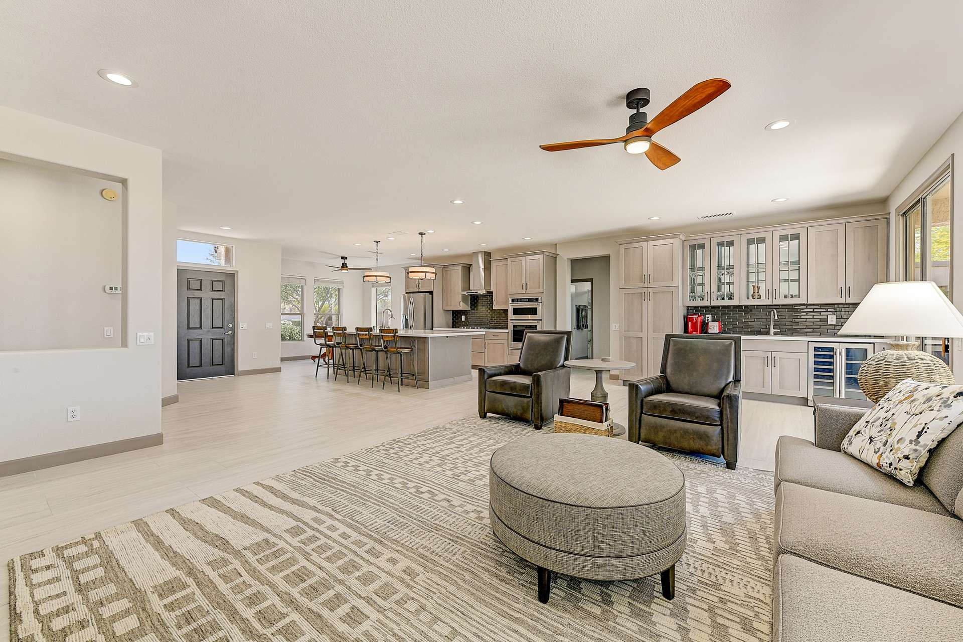 4 of 35. The open-concept living area flows effortlessly into the entryway and kitchen, combining functionality with a warm, modern aesthetic. With flexible space for both casual lounging and formal hosting, this great room adapts to every lifestyle.