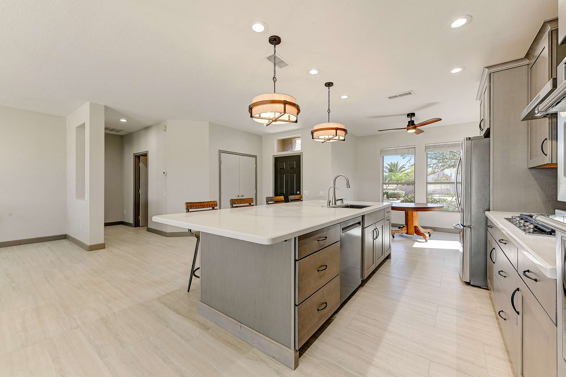 6 of 35. Sleek cabinetry, KitchenAid stainless appliances, and a quartz-topped island define this chef-inspired kitchen. Elegant design meets everyday utility with soft-close drawers, a custom backsplash, and generous storage throughout.