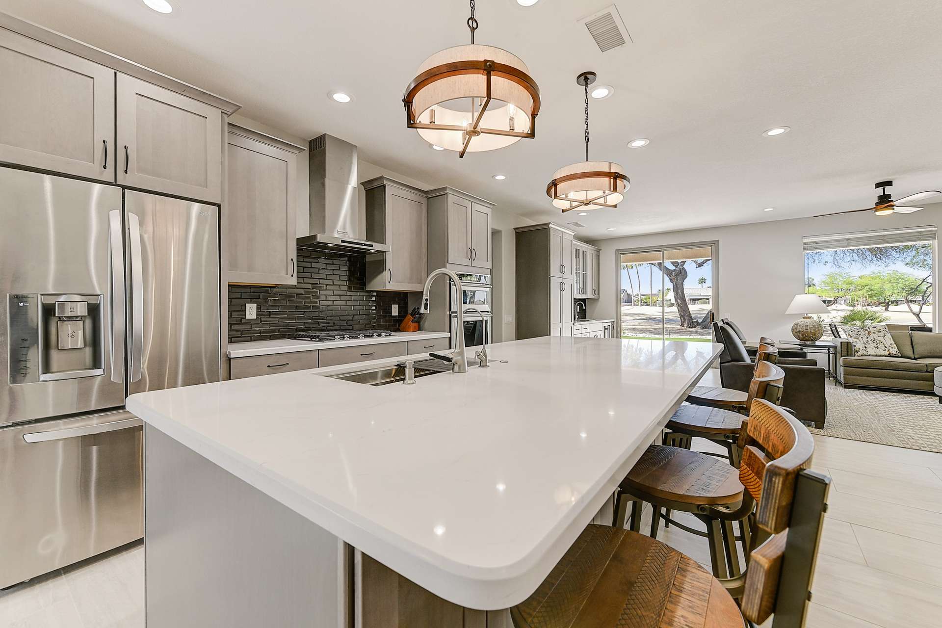 7 of 35. Gather around this oversized island that serves as a stylish anchor to the kitchen. With rich wood tones, overhead lighting, and built-in storage, this space is perfect for morning coffee, casual meals, or wine with friends.