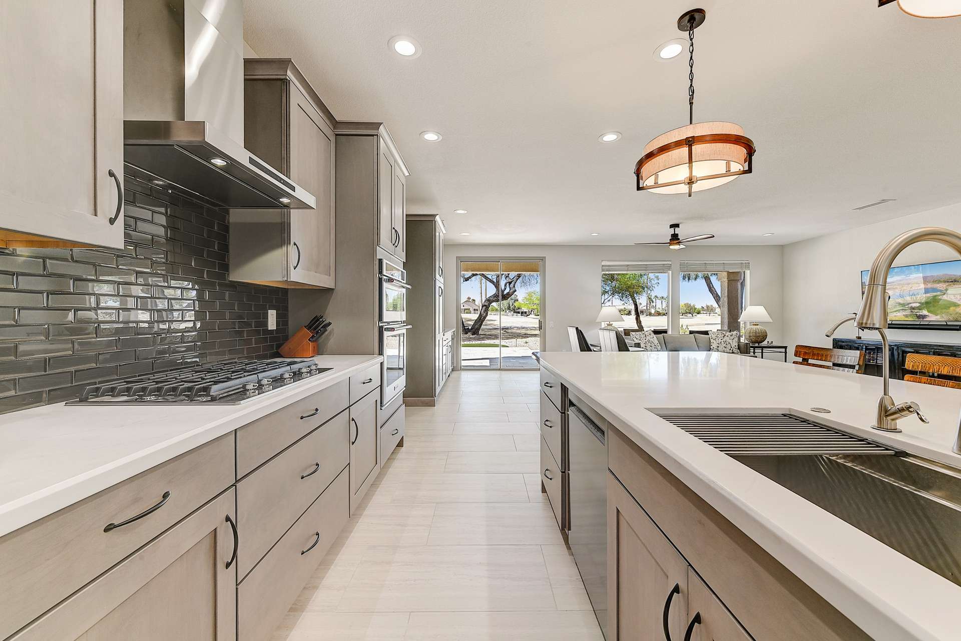 8 of 35. A modern cooking experience awaits with a stainless steel hood, gas cooktop, and polished tile backsplash. Whether hosting or meal-prepping, this setup is as functional as it is magazine-worthy.