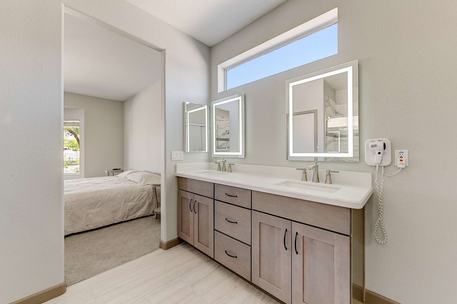 18 of 35. Enjoy sleek quartz surfaces, LED-lit mirrors, and sophisticated fixtures in this beautifully updated primary bathroom. Its clean lines and light-filled design elevate your daily routine with ease.