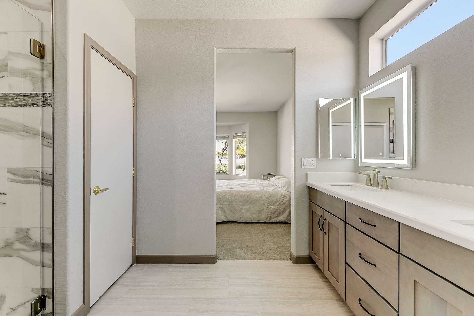 19 of 35. This ensuite bathroom delivers both privacy and polish, featuring a modern vanity, LED lighting, and high-end finishes. The seamless layout connects to the primary suite for a cohesive and comfortable flow.