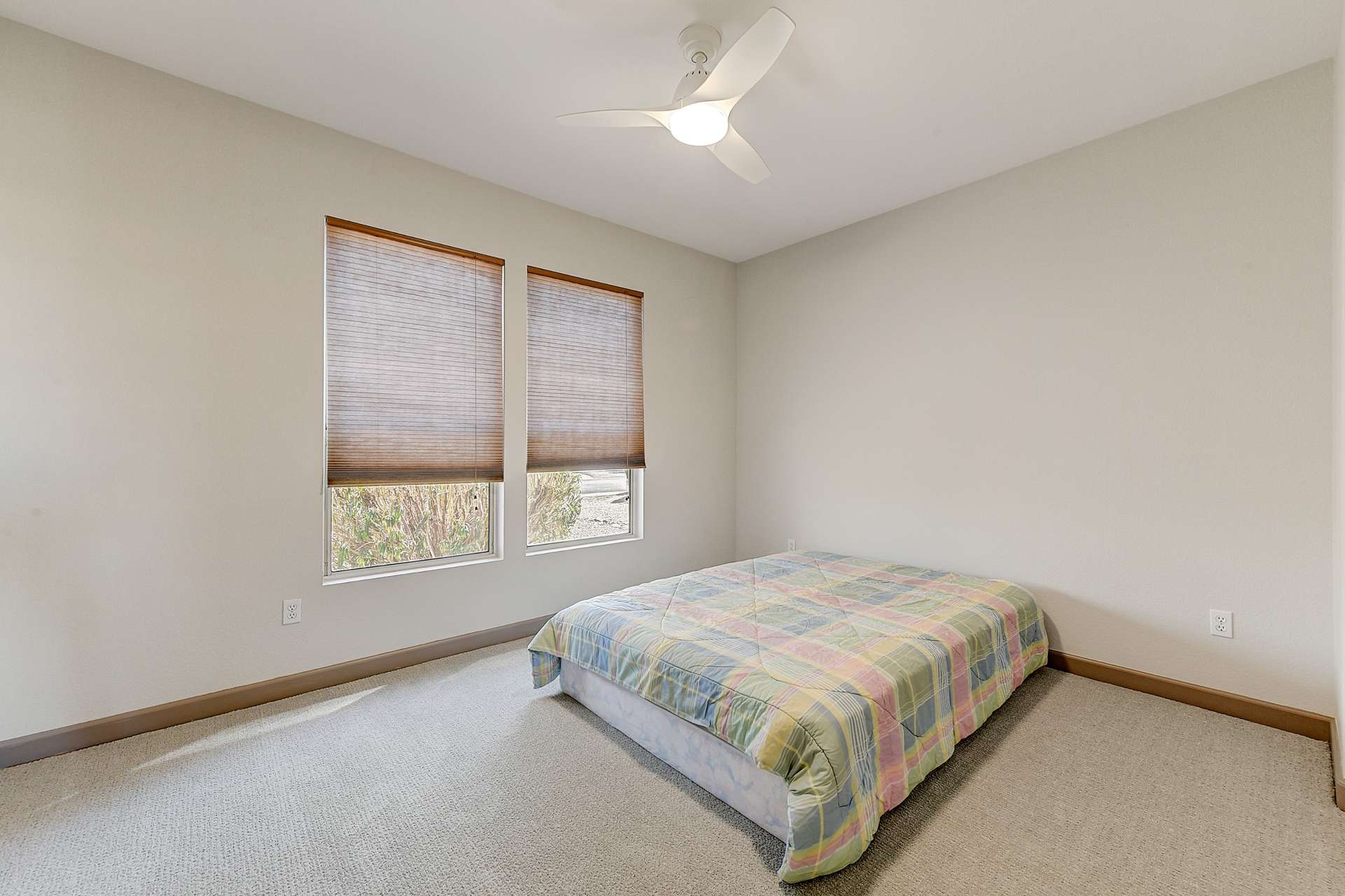 22 of 35. Soft-filtered light and calming neutral paint create a welcoming atmosphere in this third bedroom. Energy-efficient ceiling fan and plush carpet complete this serene space.