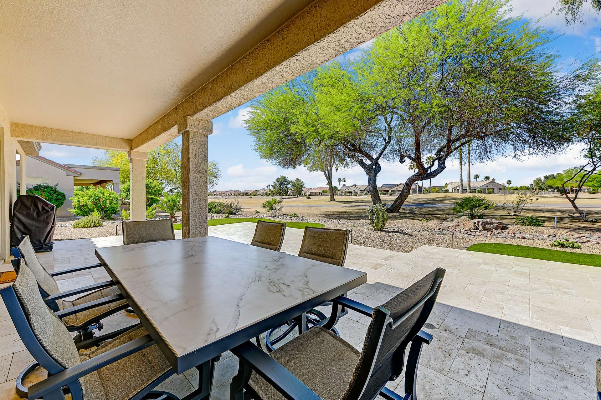 25 of 35. The covered travertine patio extends your living space with elegant finishes and shade from mature trees. Enjoy golf course views and alfresco dining year-round.