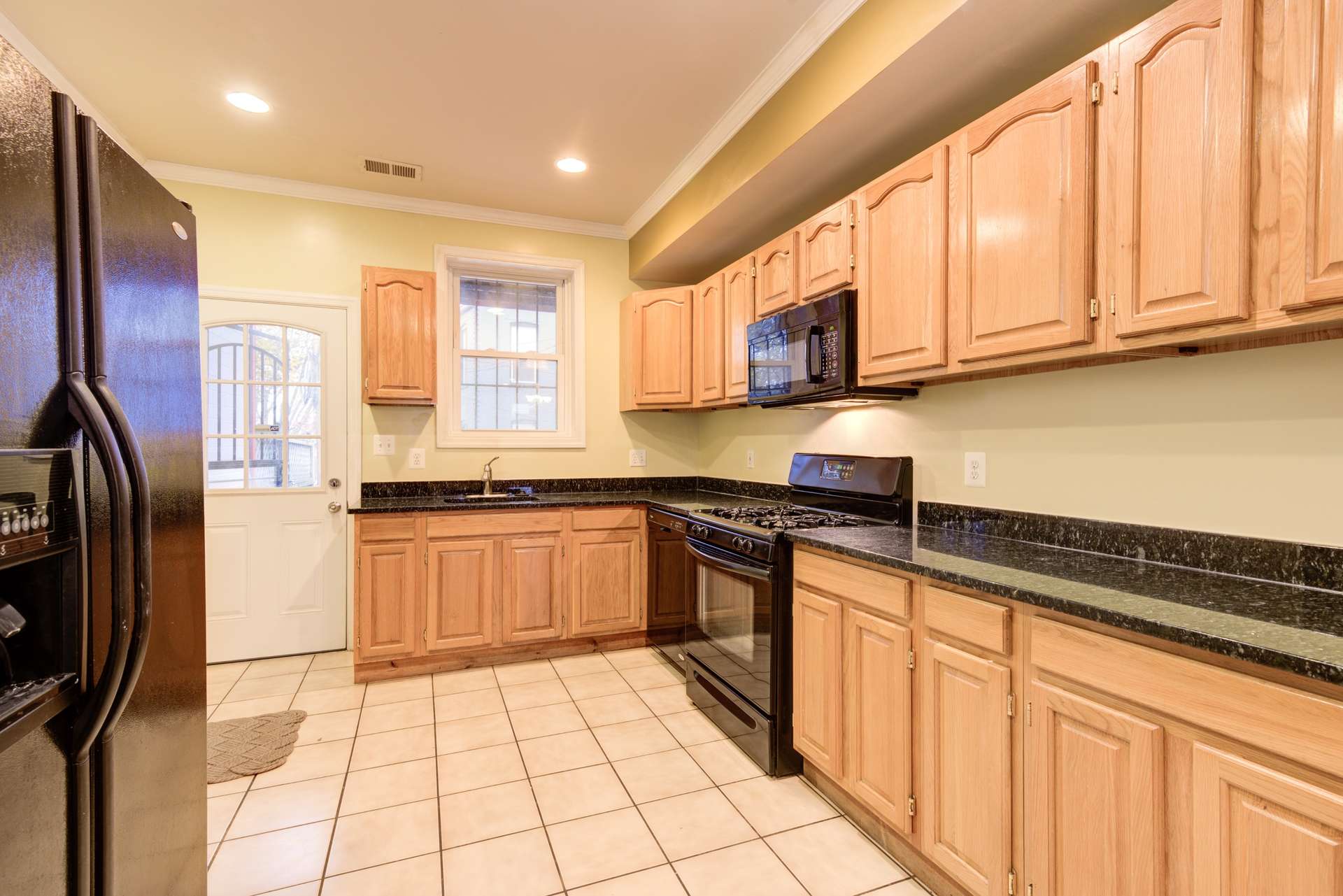 10 of 42. The kitchen has granite countertops, a built-in microwave, and a gas range.