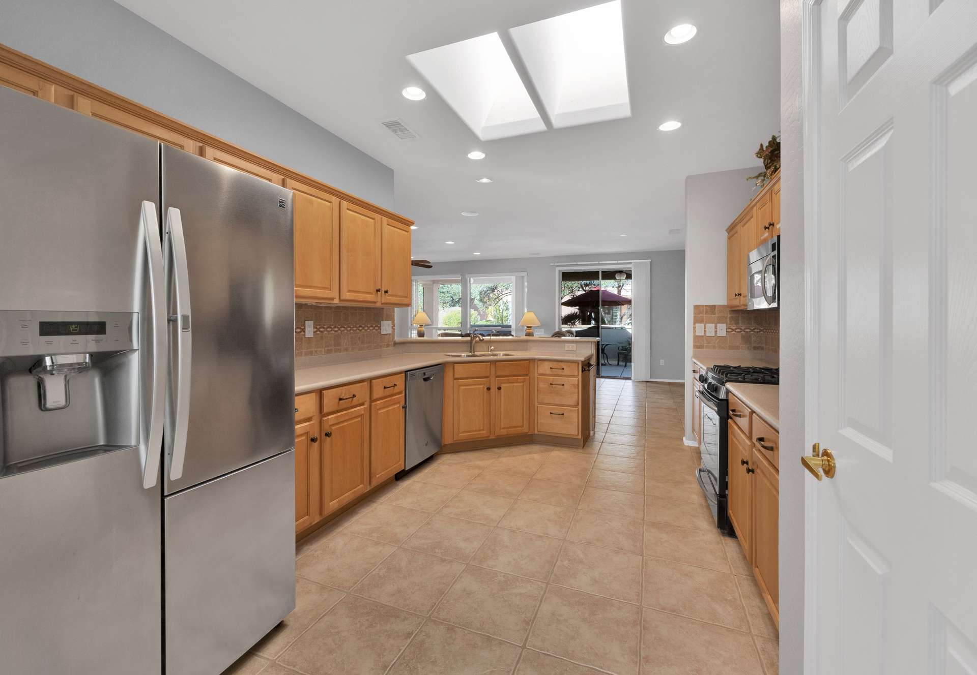 4 of 13. Natural light pours in through dual skylights, illuminating ample counter space and a seamless layout perfect for preparing meals or entertaining guests during your Arizona getaway.