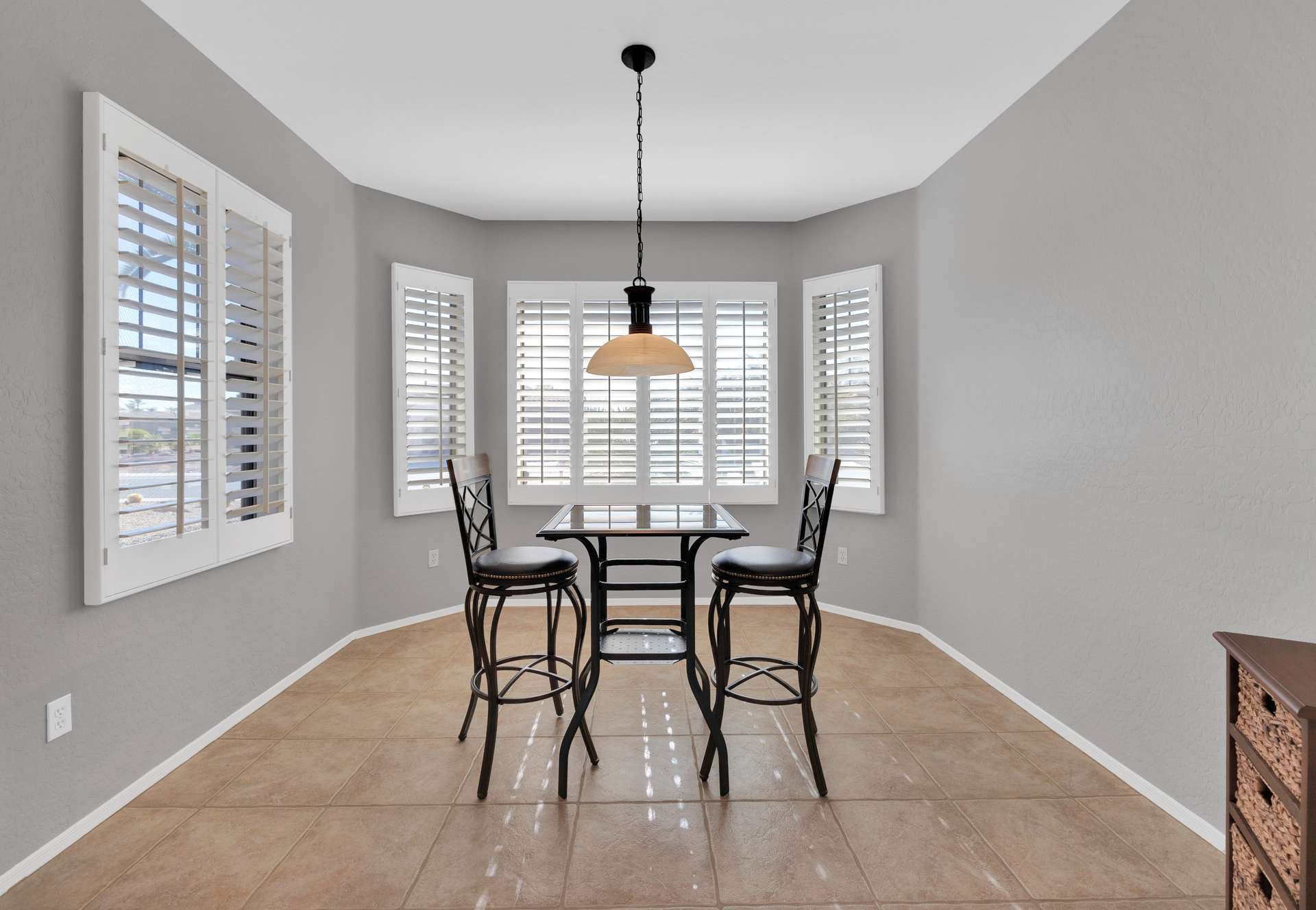 5 of 13. Enjoy your morning coffee or a casual lunch in this inviting breakfast nook framed by plantation shutters and scenic desert views just steps from the kitchen.