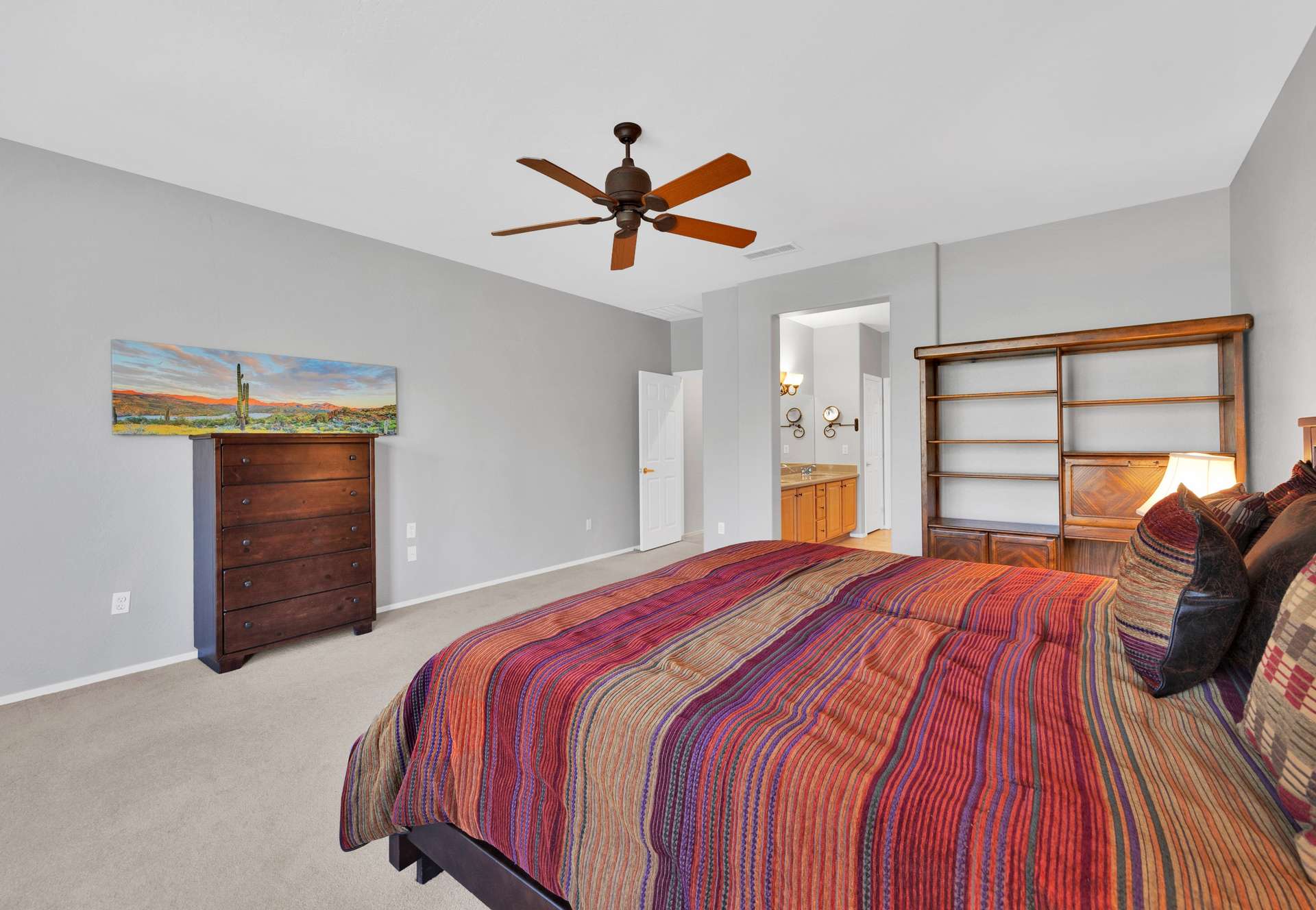 7 of 13. This generously sized primary bedroom includes direct access to the en-suite bathroom, neutral colors, and plenty of space ideal for long or short-term rental guests.