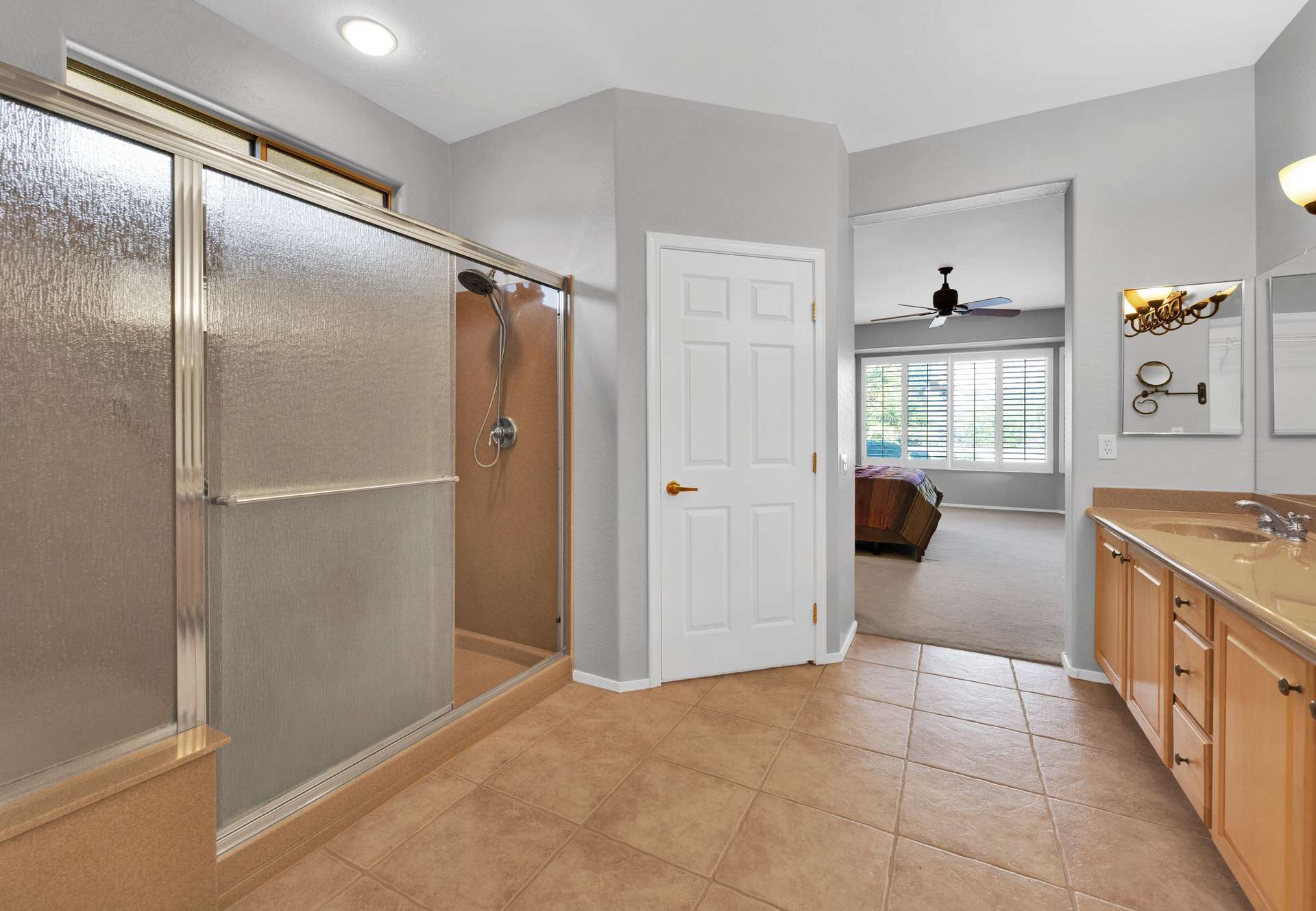 9 of 13. Enjoy a spacious step-in shower, modern fixtures, and ample room to get ready in this tastefully designed bathroom, attached to the primary suite for added privacy.