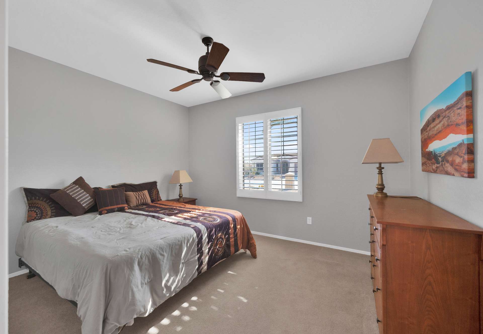 10 of 13. This secondary bedroom offers plush carpeting, large windows, and warm neutral tones perfect for visiting guests or a flexible work-from-home setup in your Surprise rental.
