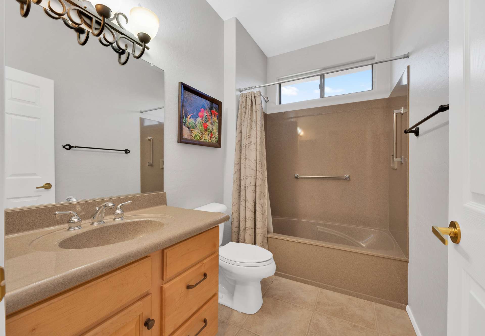 12 of 13. This updated hallway bathroom features a sleek solid-surface countertop, modern lighting, and a full tub-shower combo. An ideal setup for guests staying in this fully furnished Surprise rental.