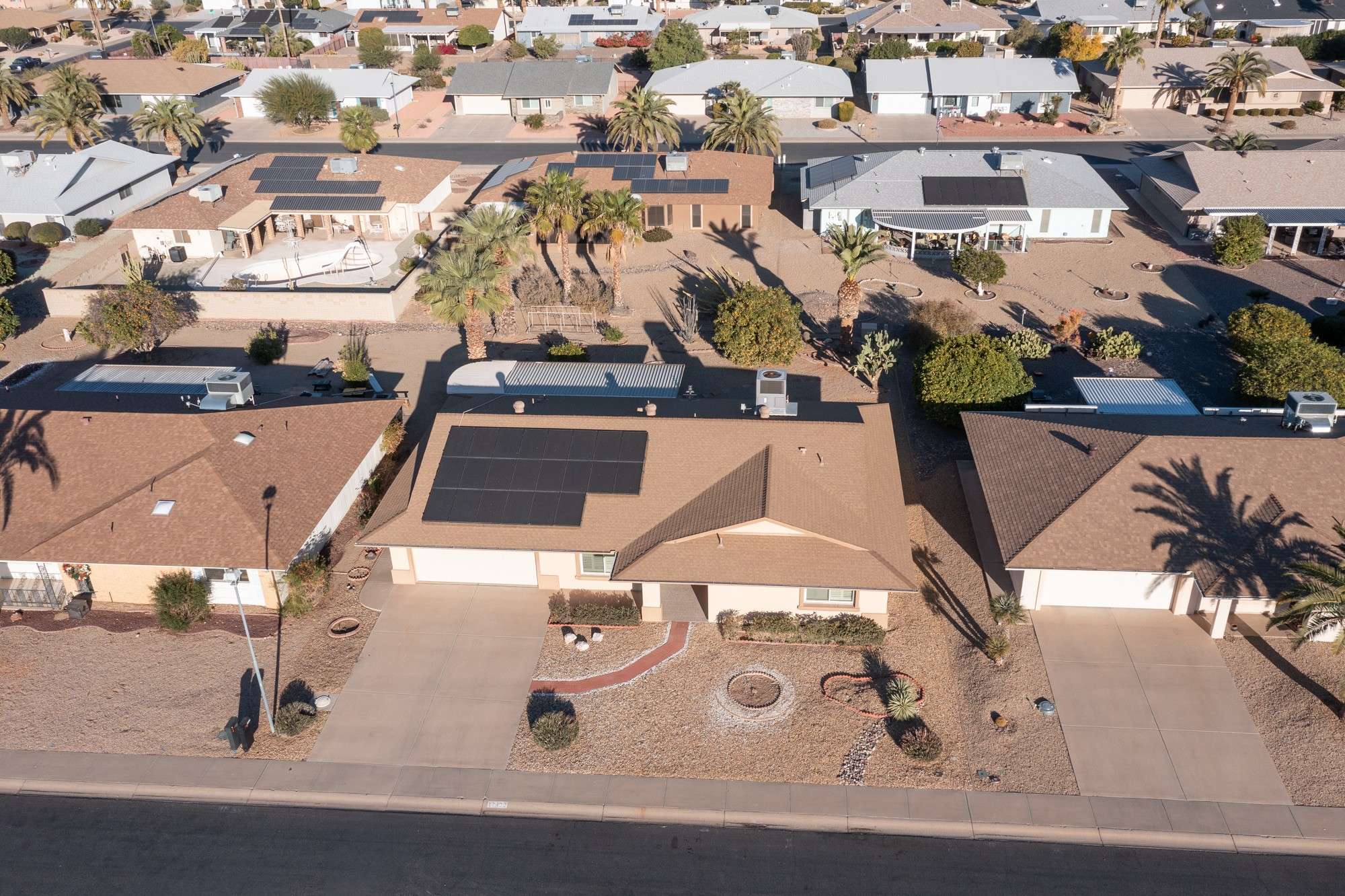 8 of 48. A ground-level view of this home's stunning low-maintenance yard, featuring decorative rocks and desert-friendly plants, perfectly aligned with Arizona's climate and aesthetic.