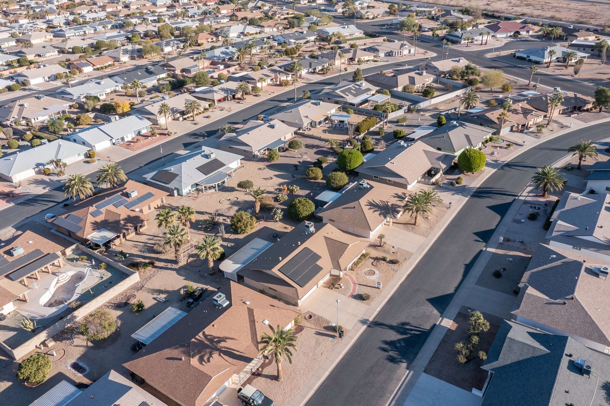 2 of 48. A panoramic view capturing the charm of Sun City West with its palm-lined streets, beautifully maintained homes, and a vibrant community ideal for active adults.