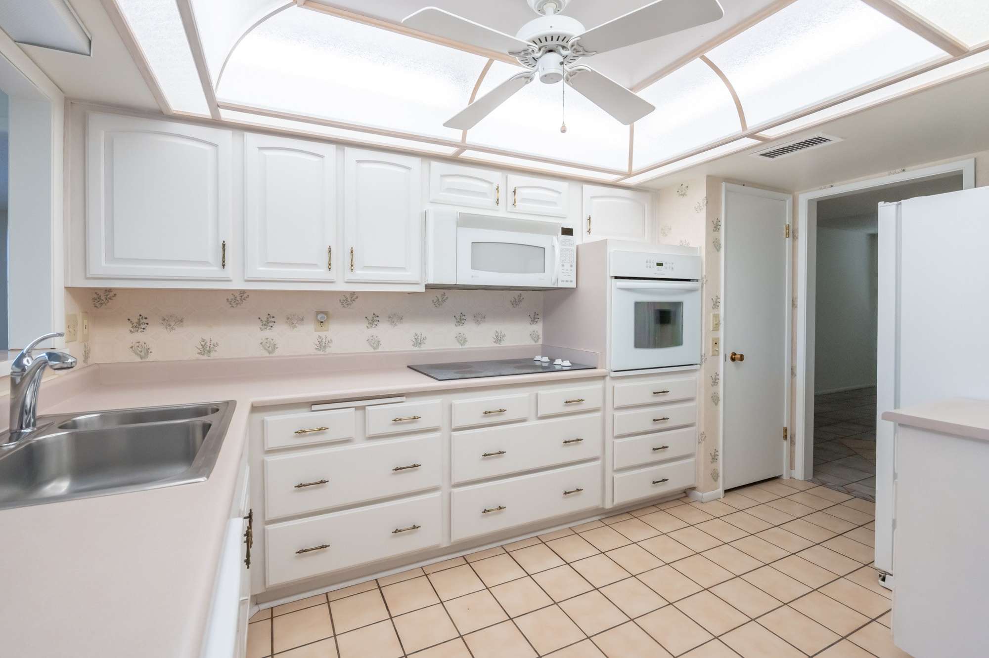 4 of 48. A well-appointed kitchen with plenty of counter space and natural light streaming in through the windows. Perfect for meal preparation and casual dining.