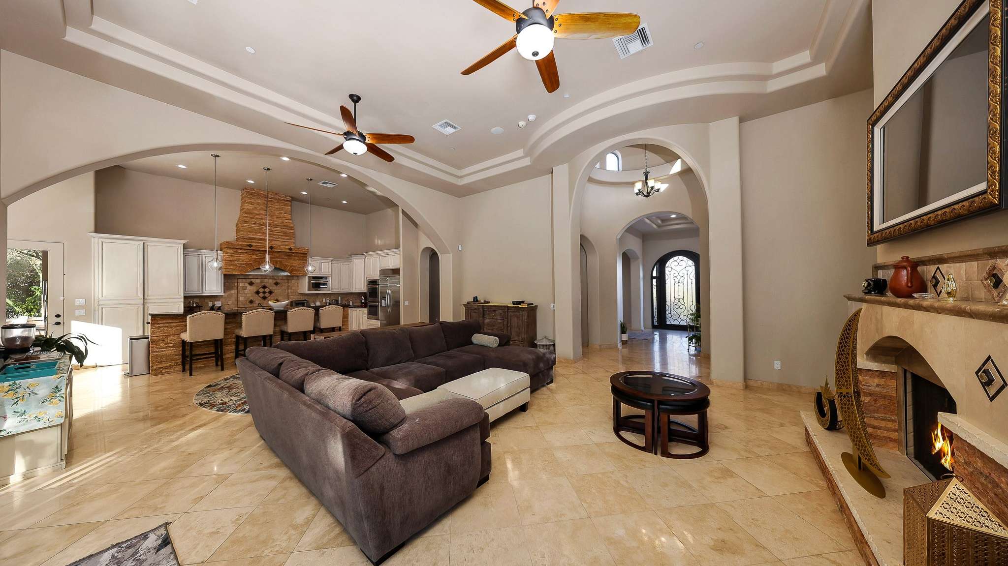 10 of 39. A spacious great room with a stunning fireplace centerpiece, arching transitions, and views into the chef s kitchen. Designed for relaxing, hosting, and enjoying the best of Scottsdale indoor living.