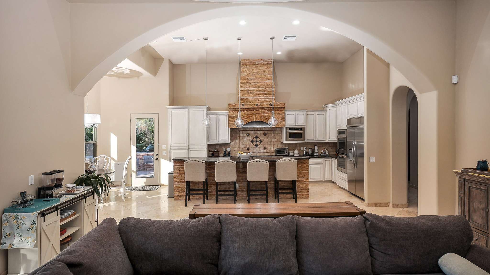 11 of 39. This grand kitchen layout blends effortlessly into the main living space with arched accents, pendant lighting, and elegant tile flooring. Designed for both beauty and function, it s ideal for Scottsdale buyers who value space and seamless entertaining.