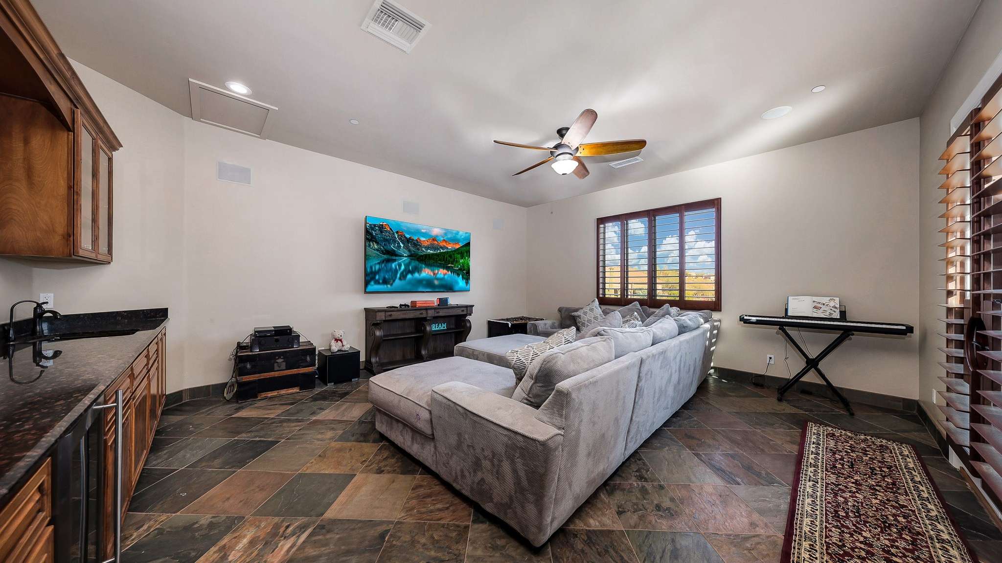 20 of 39. A perfect retreat for movie nights or entertaining, this large flex room features a wet bar, slate floors, and built-in cabinetry. This Scottsdale bonus space offers comfort and versatility for families and guests alike.
