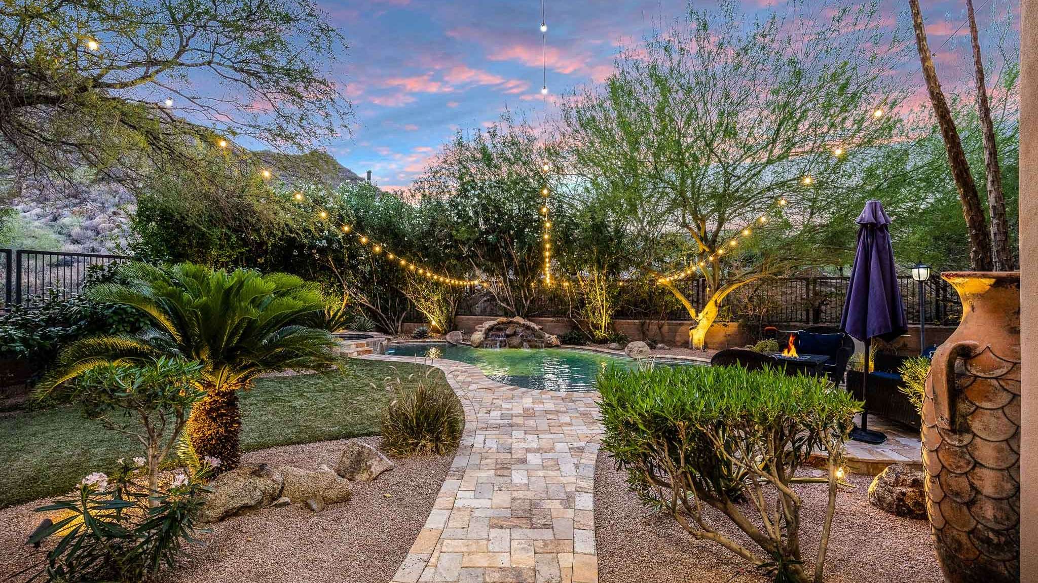 25 of 39. An inviting view of this Scottsdale property s private oasis highlights evening lighting, a lush lawn, and thoughtfully designed outdoor zones for play, rest, and celebration.