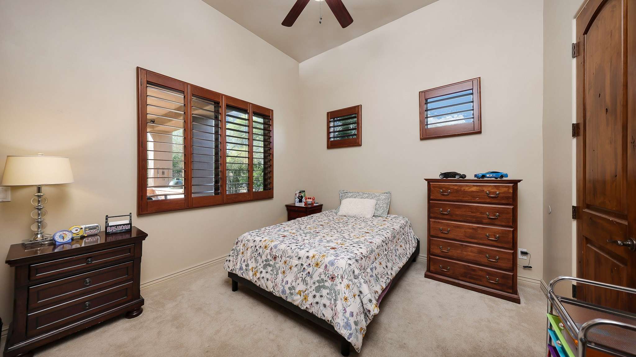29 of 39. This secondary bedroom features warm wood accents, high ceilings, and plush carpeting. A quiet space in the home ideal for visitors or versatile enough for a nursery or workspace.