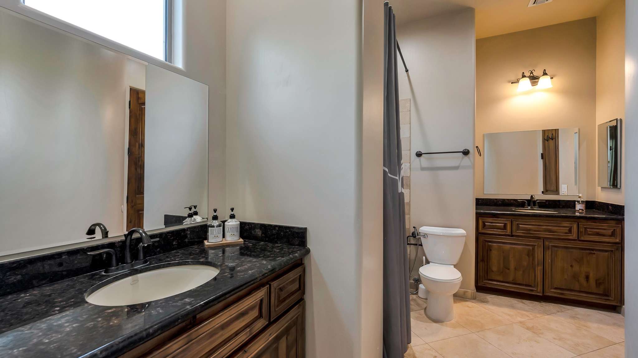 30 of 39. A spacious Jack and Jill bathroom with dual sinks, rich cabinetry, and granite counters. This Scottsdale layout is both functional and stylish perfect for shared use among family or guests.