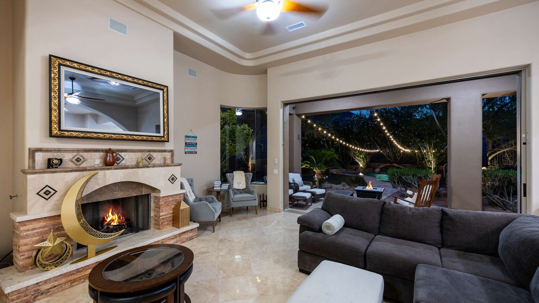 34 of 39. A cozy fireplace anchors the living space, while retractable sliders invite you into the illuminated backyard oasis. Indoor-outdoor living at its best in Scottsdale.