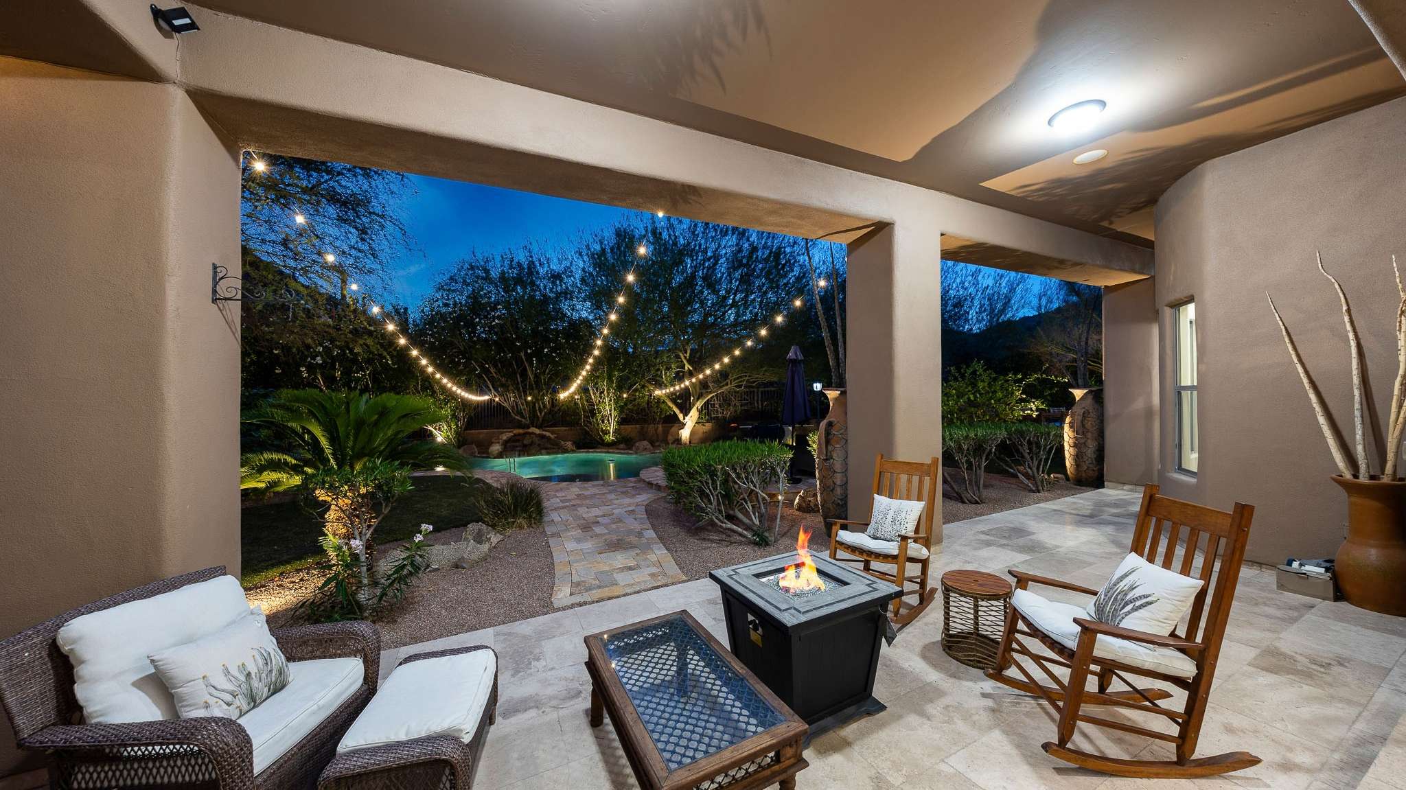 35 of 39. Enjoy Scottsdale evenings on this spacious patio with ambient lighting, built-in fire pit, and ample seating perfect for year-round entertaining and relaxation.