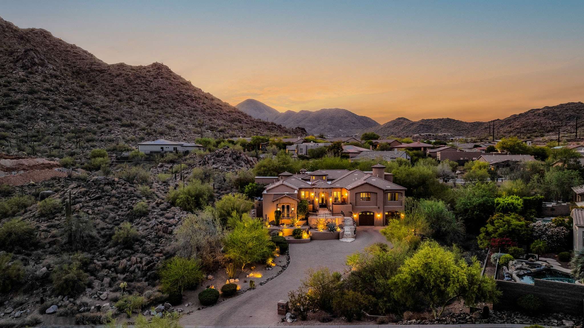36 of 39. Surrounded by rugged mountains, this Scottsdale home offers stunning curb appeal, expansive grounds, and a warm desert glow. A picturesque setting with privacy and grandeur.