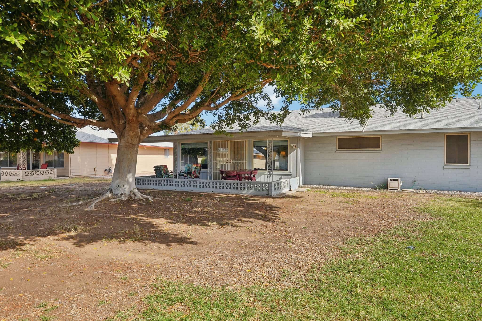 41 of 41. The large shade tree in this peaceful backyard creates a cool and comfortable outdoor living space, while the covered patio offers the perfect spot for dining or unwinding.