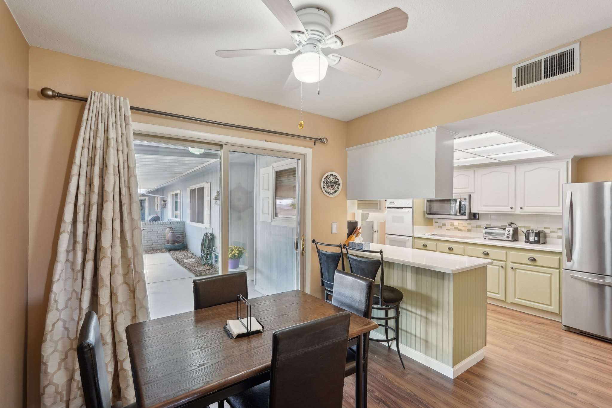 10 of 41. Enjoy indoor-outdoor living with this bright breakfast nook that leads to the covered patio. A perfect space for casual meals with natural light and easy access to the backyard.