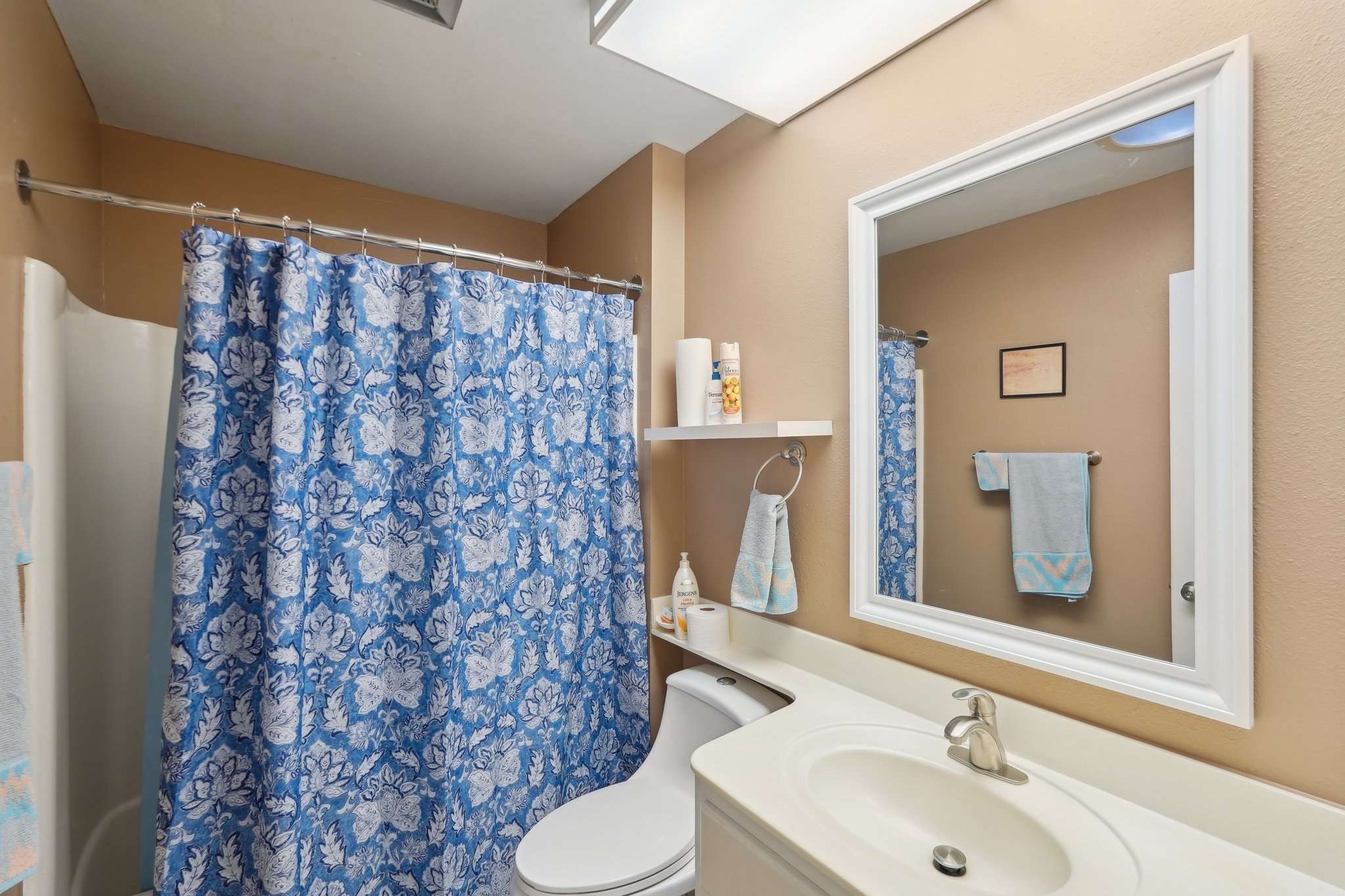 19 of 41. This modern guest bathroom offers a sleek vanity, built-in shelving, and a framed mirror. The neutral palette makes it both stylish and functional.