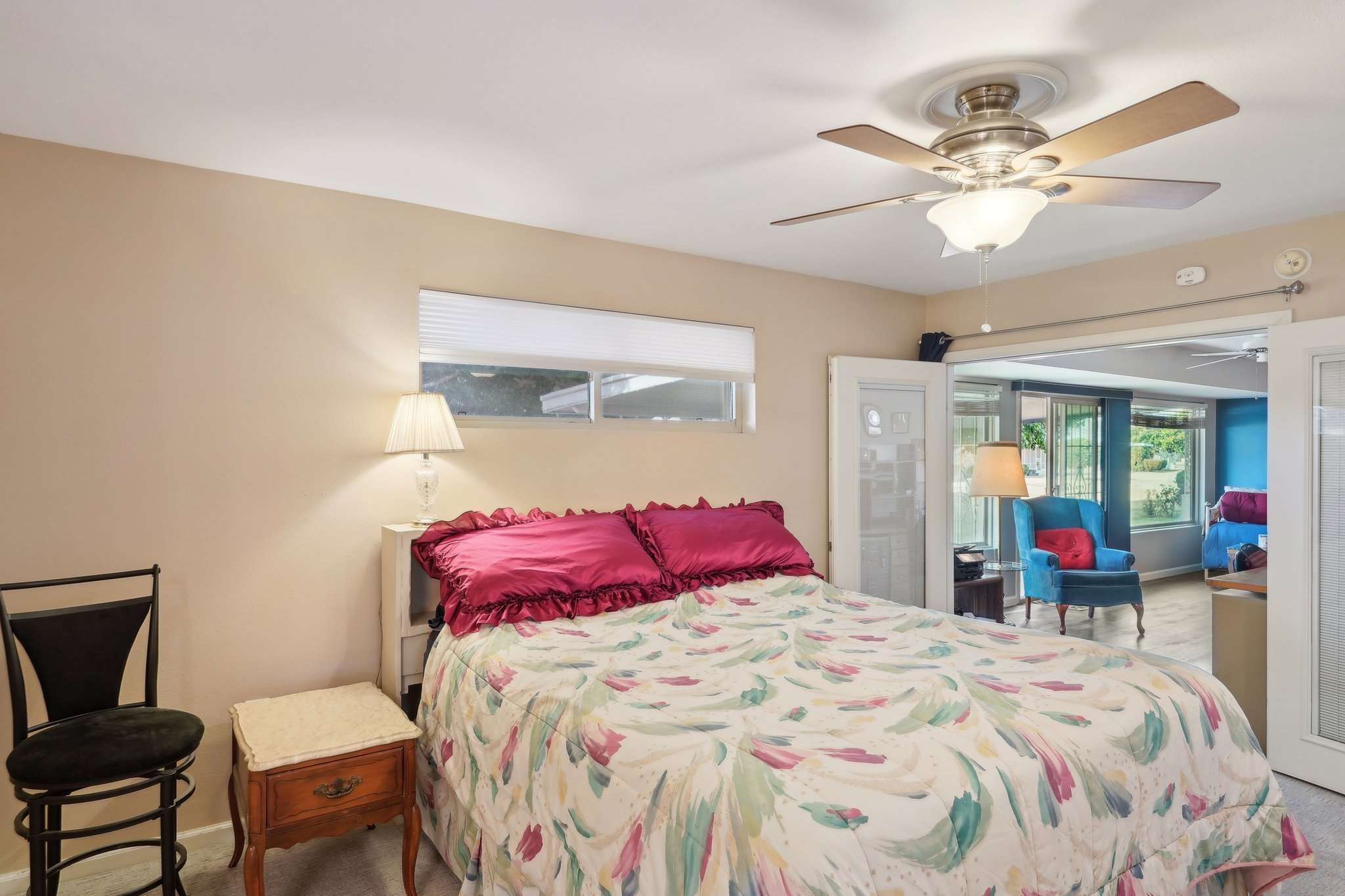 30 of 41. This primary bedroom offers a private retreat with direct access to the Arizona room, a ceiling fan for added comfort, and a high-set window for natural light.