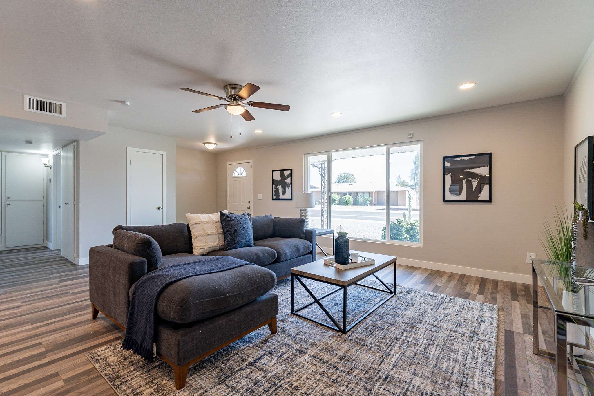 8 of 35. This remodeled living space offers a seamless flow between the family room, dining area, and kitchen. Large windows, recessed lighting, and neutral finishes create a warm and inviting atmosphere.