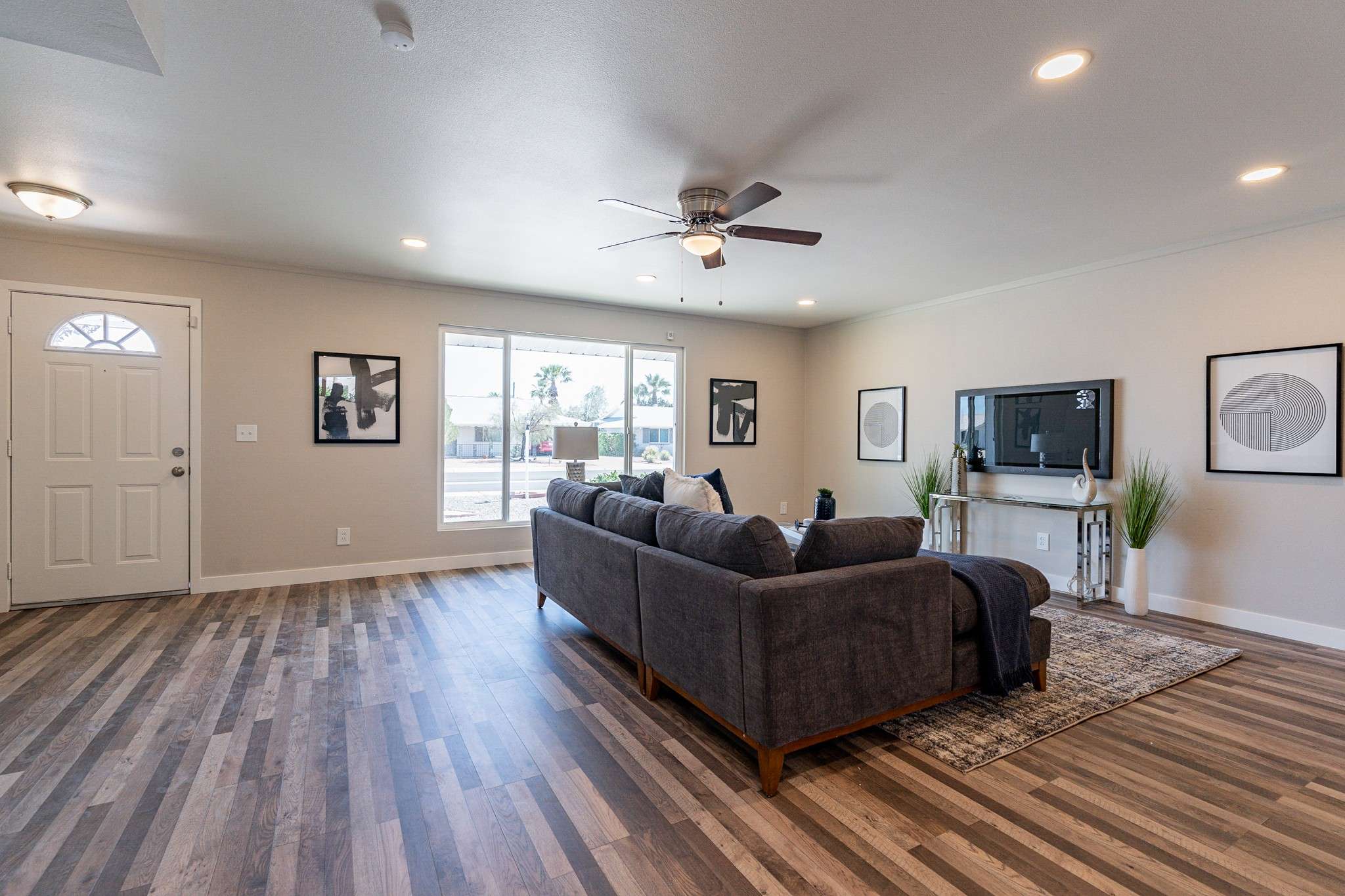 9 of 35. A spacious and inviting living area with updated flooring, fresh paint, and recessed lighting. Perfect for entertaining or enjoying peaceful Sun City living.