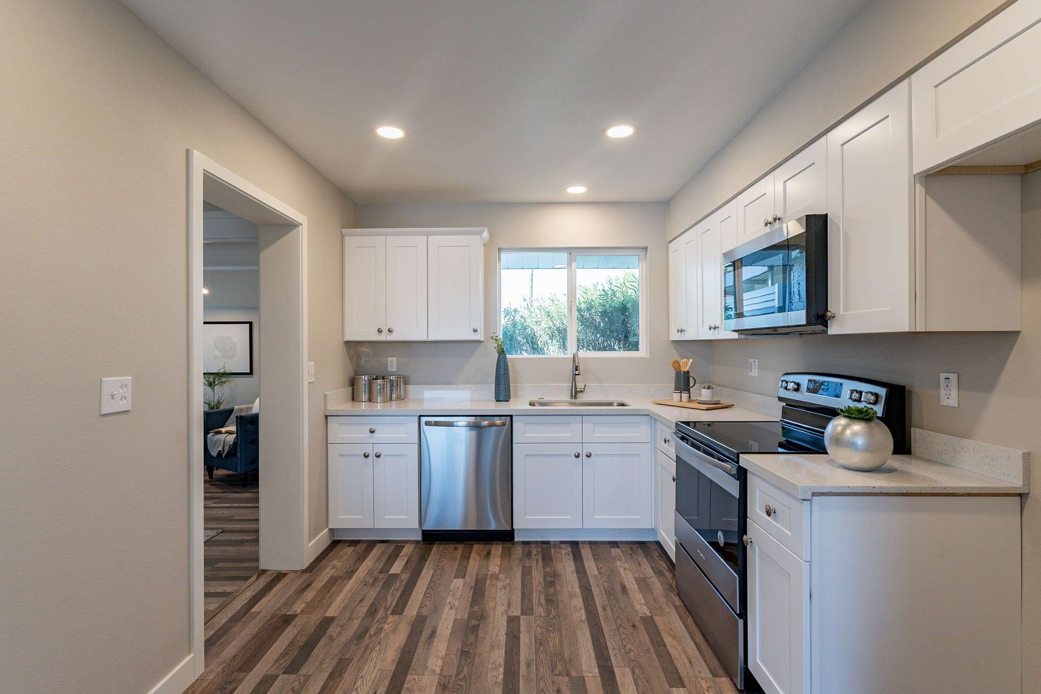 18 of 35. The modern kitchen features shaker-style white cabinetry, a large window for natural light, and high-end finishes. A stylish and practical space for any homeowner.