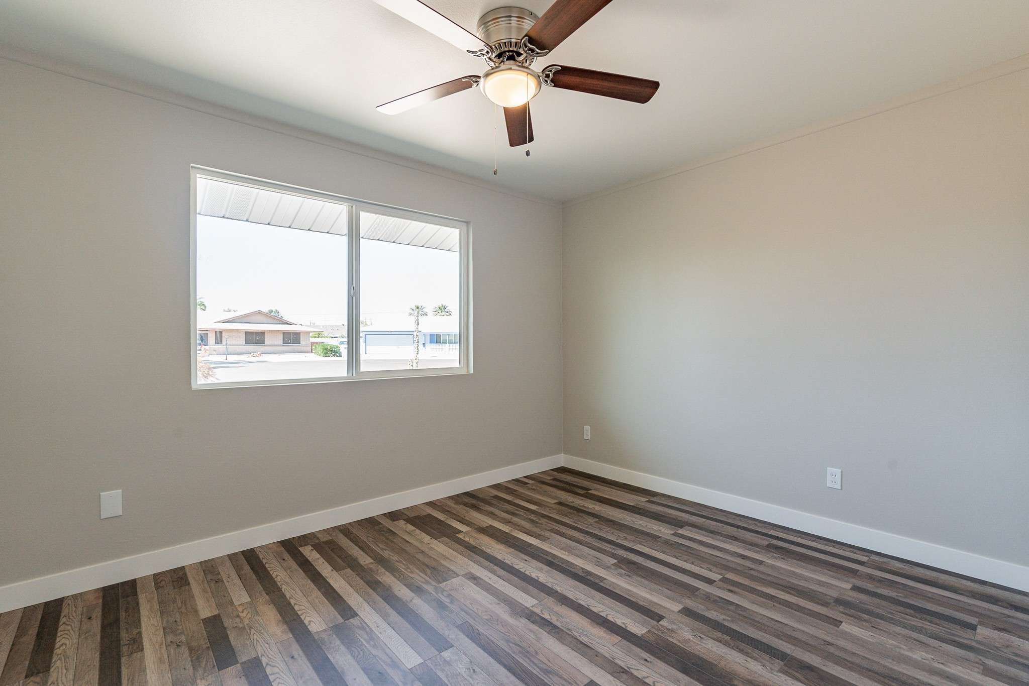 23 of 35. Wake up to beautiful natural light in this bright bedroom. The large windows offer a peaceful view, while the ceiling fan and modern flooring add comfort and style.