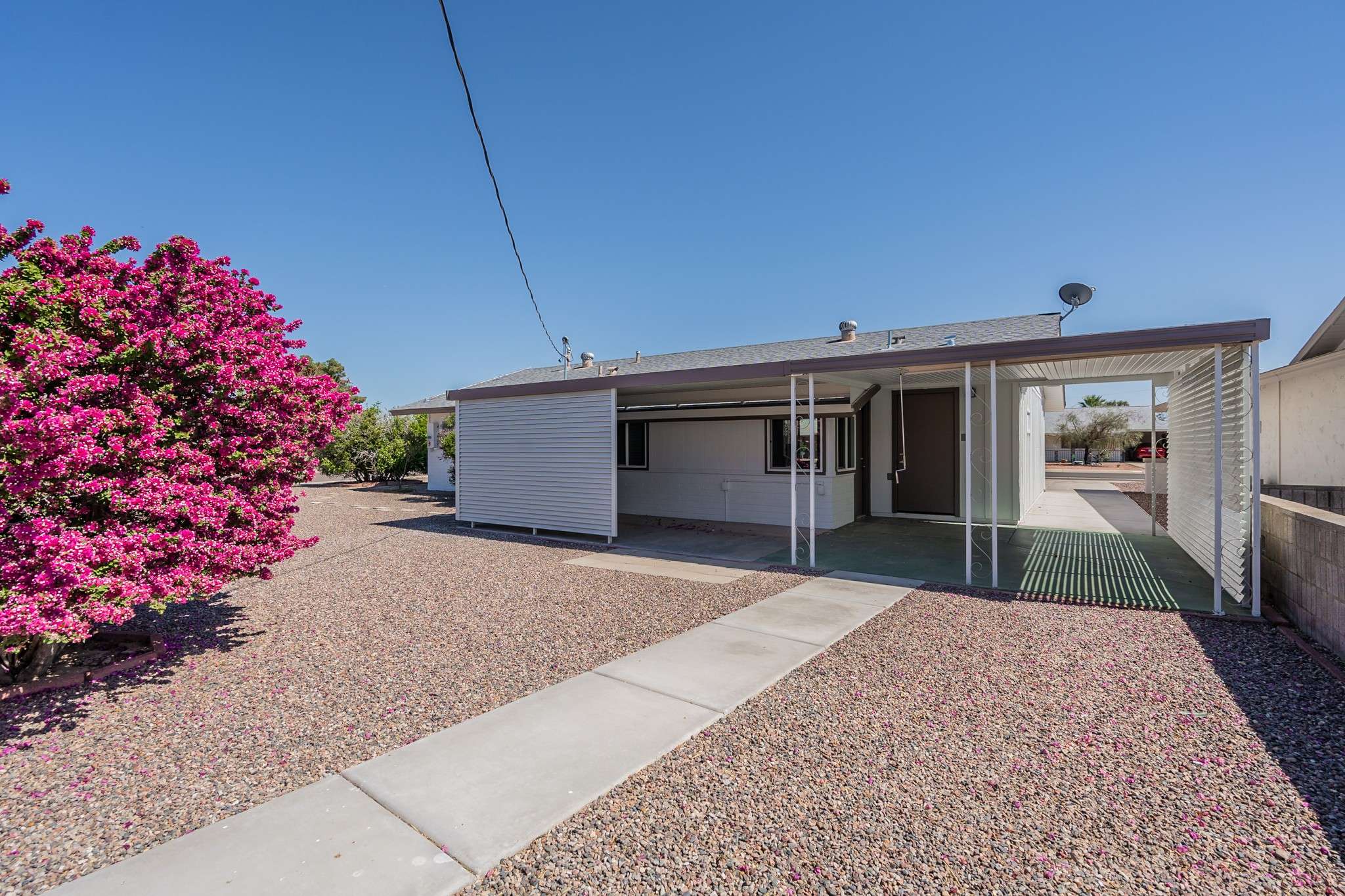 30 of 35. A beautifully landscaped backyard with a shaded patio, perfect for outdoor dining or lounging. Low-maintenance features make it an ideal space for relaxation.